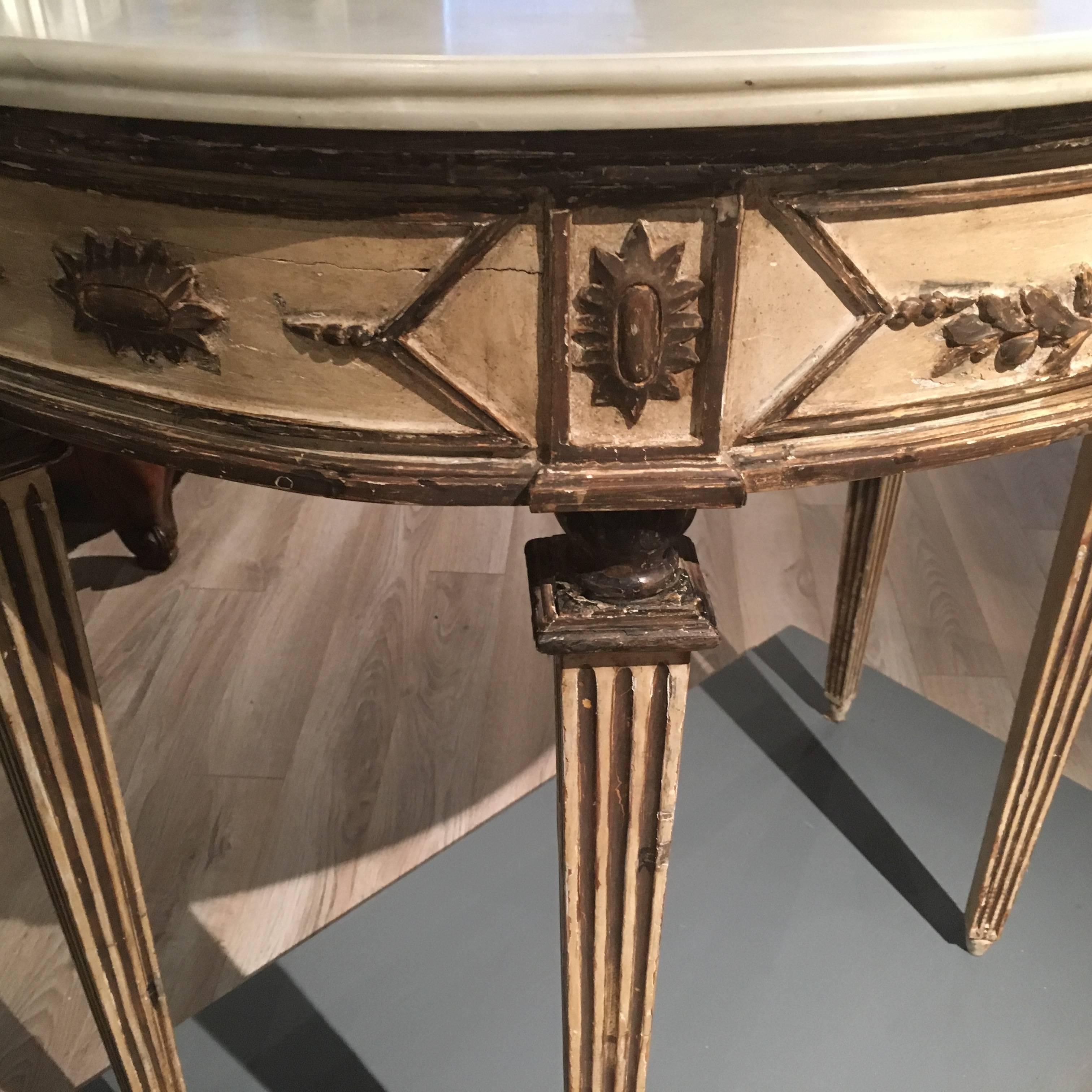 A very nice Italian early 19th century demilune console table with grisaille decoration of garlands and a central basket with square tapered and fluted legs and a white Carrara marble-top.