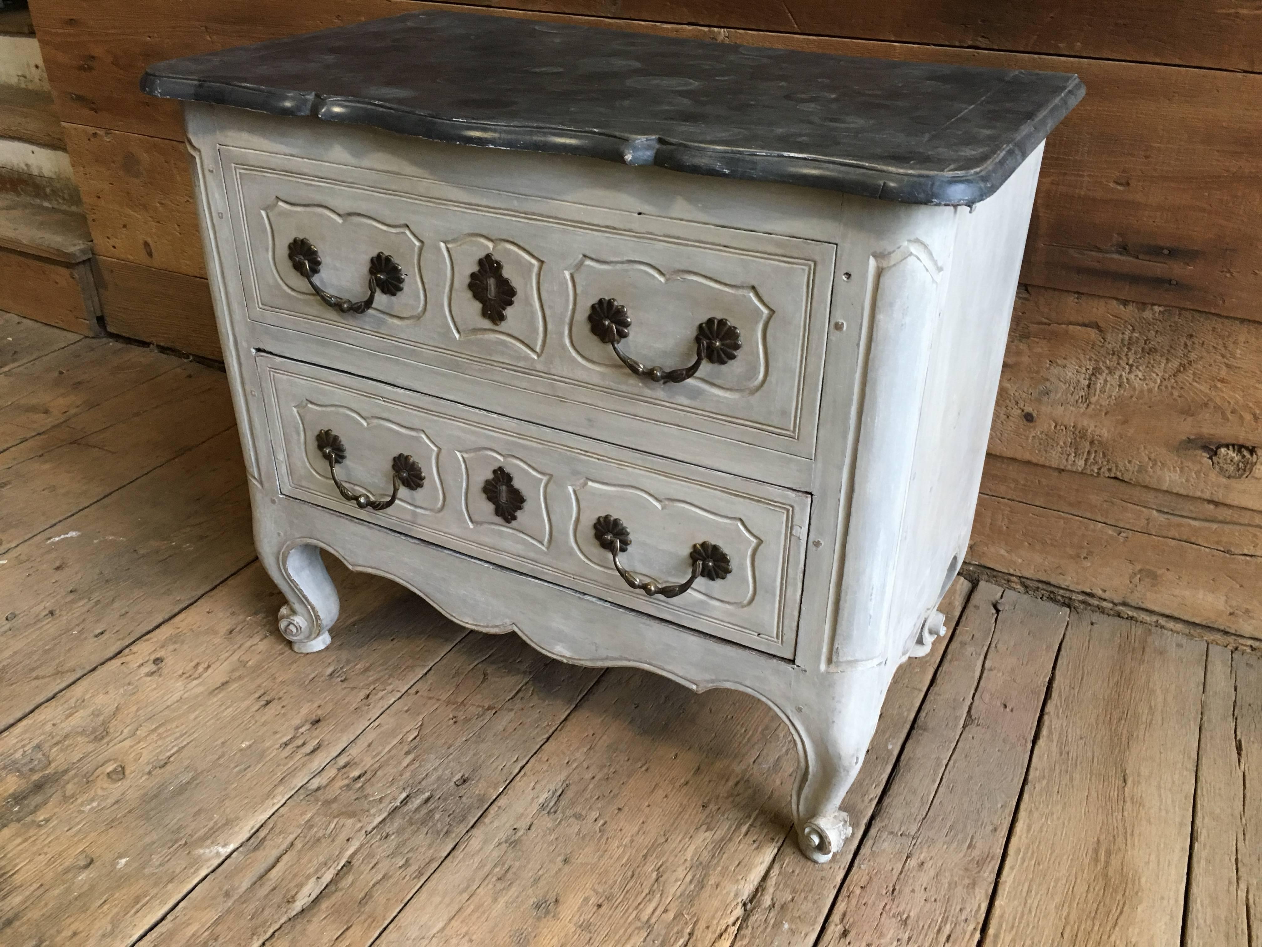 An 18th century French Louis XV petite commode in grey paint with faux marble wood top, circa 1770. The cabinet consists of two drawers (a false top drawer and a full length lower drawer) raised on cabriole legs with carved feet. The wood top is