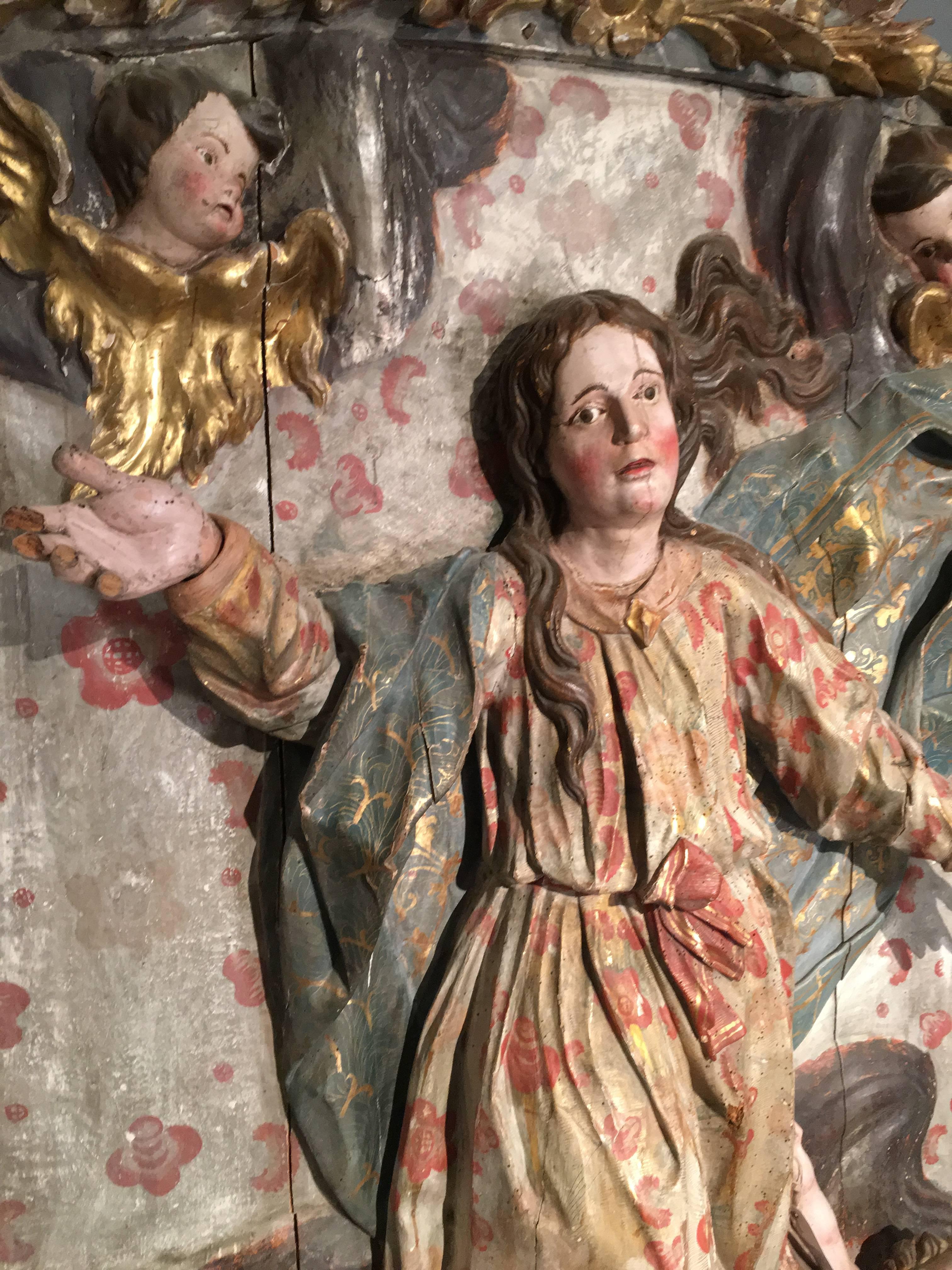 A large and important Baroque carved wood high-relief altar piece depicting the assumption of the Madonna, late 17th century, Italian, retaining its original painted and parcel gilt decoration. The near life-size Madonna is depicted with