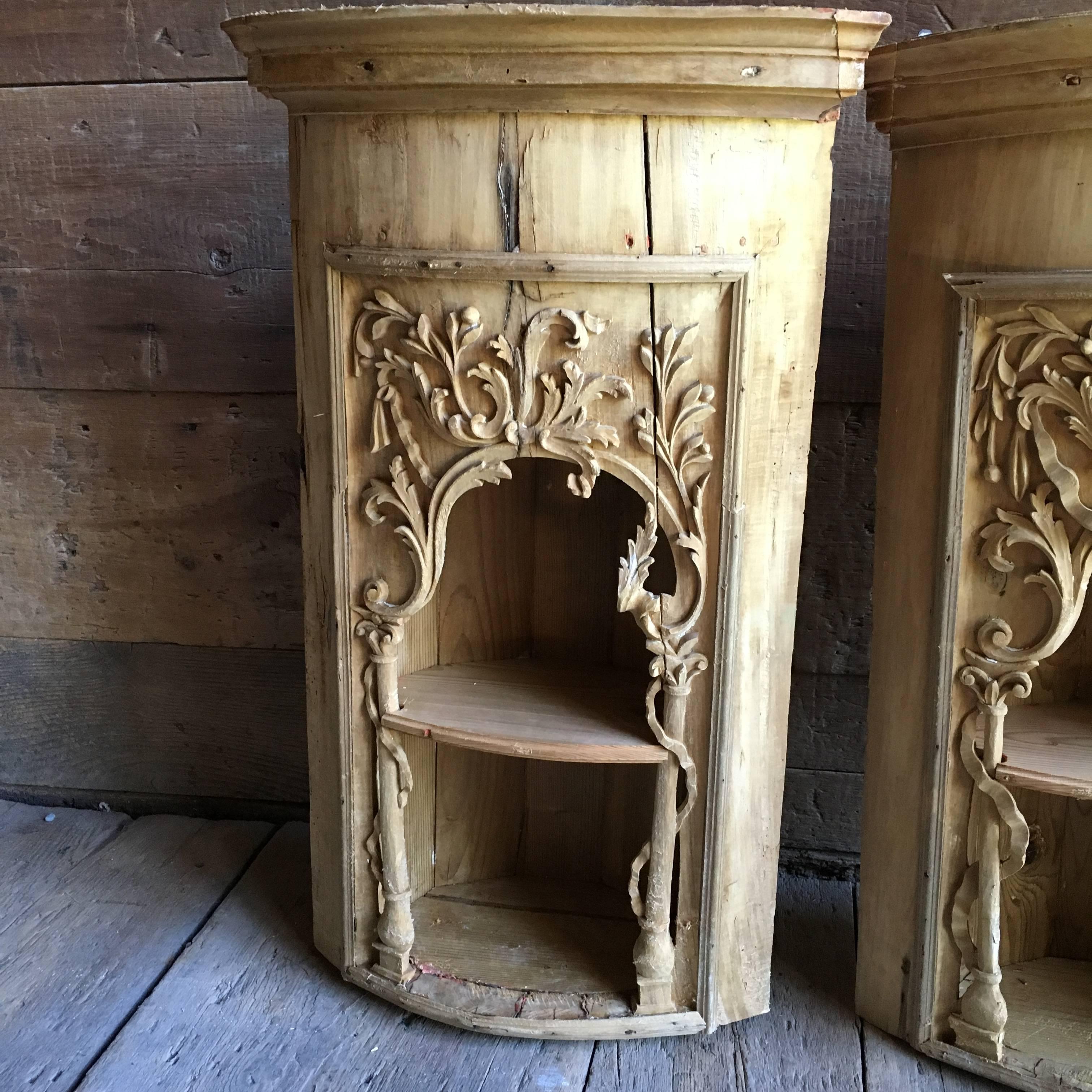 A pair of stripped and bleached pine Italian hanging corner cabinets, circa 1780, with nicely carved facades an interior shelf and a simple cornice.