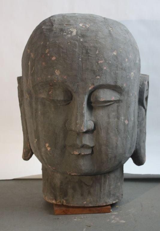 A very large carved wood Buddha head with a gesso and grey painted finish, mid 19th Century China.
