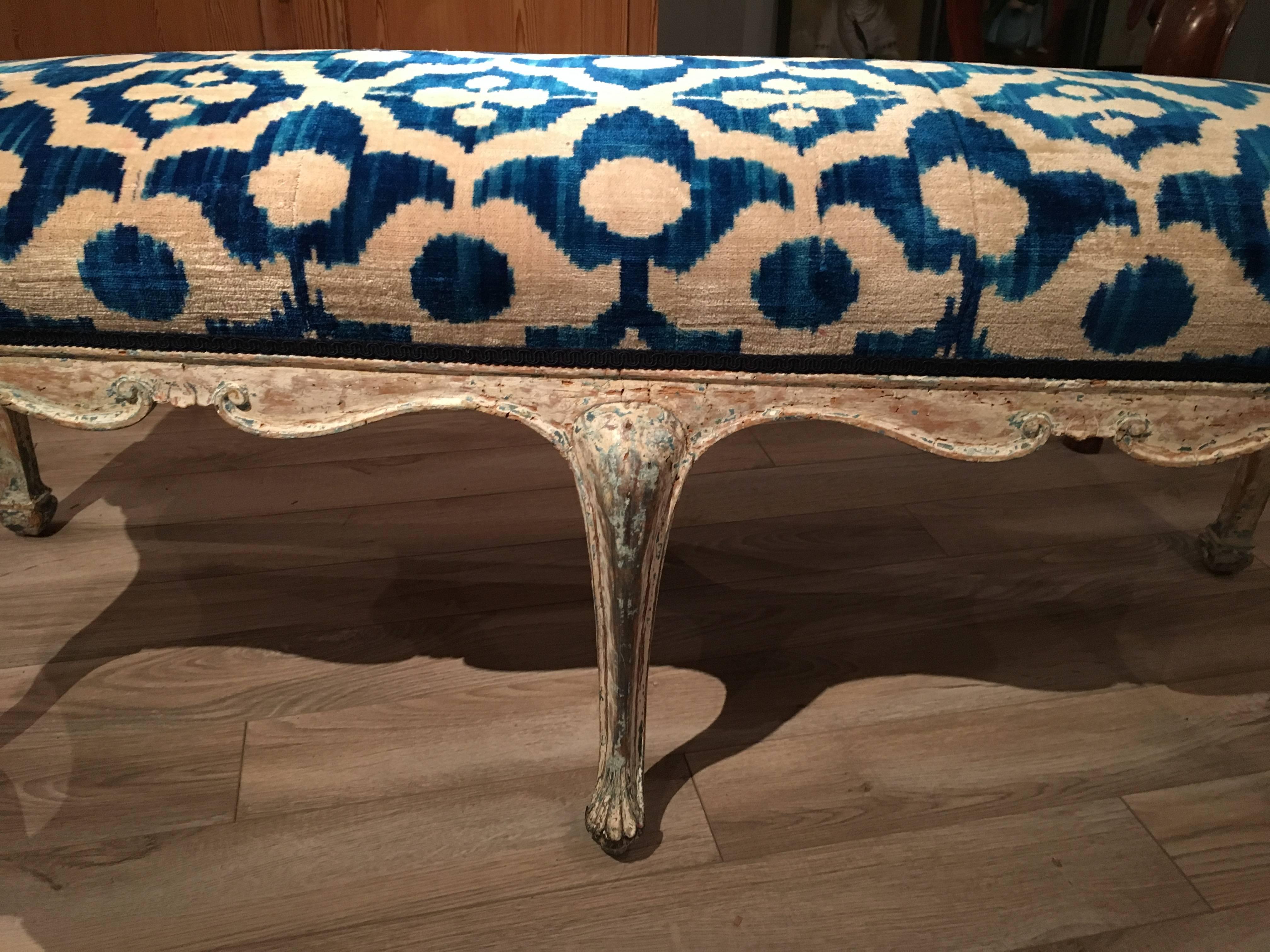 A nicely carved and sculpted Italian Louis XV style bench, late 18th century, retaining traces of its original blue and white painted finish, the frame with a carved and scalloped apron on cabriole legs, circa 1770. The bench is currently