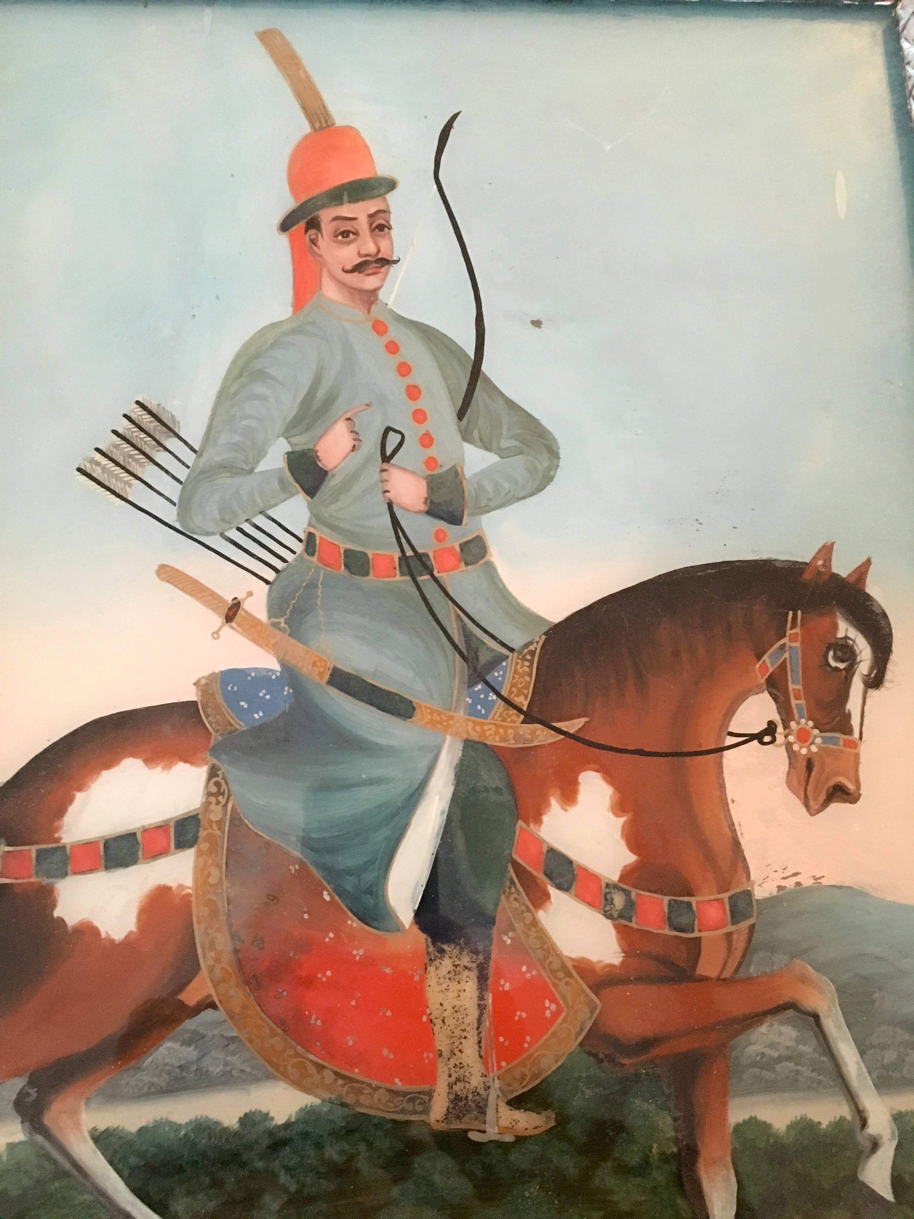 A Moghul Era églomisé (reverse painting on glass) portrait of a Sultan on horseback in a landscape, in a Louis XVI period green painted frame, early 19th century. 
From the estate of Pierre Moulin, author of French Country style books and founder