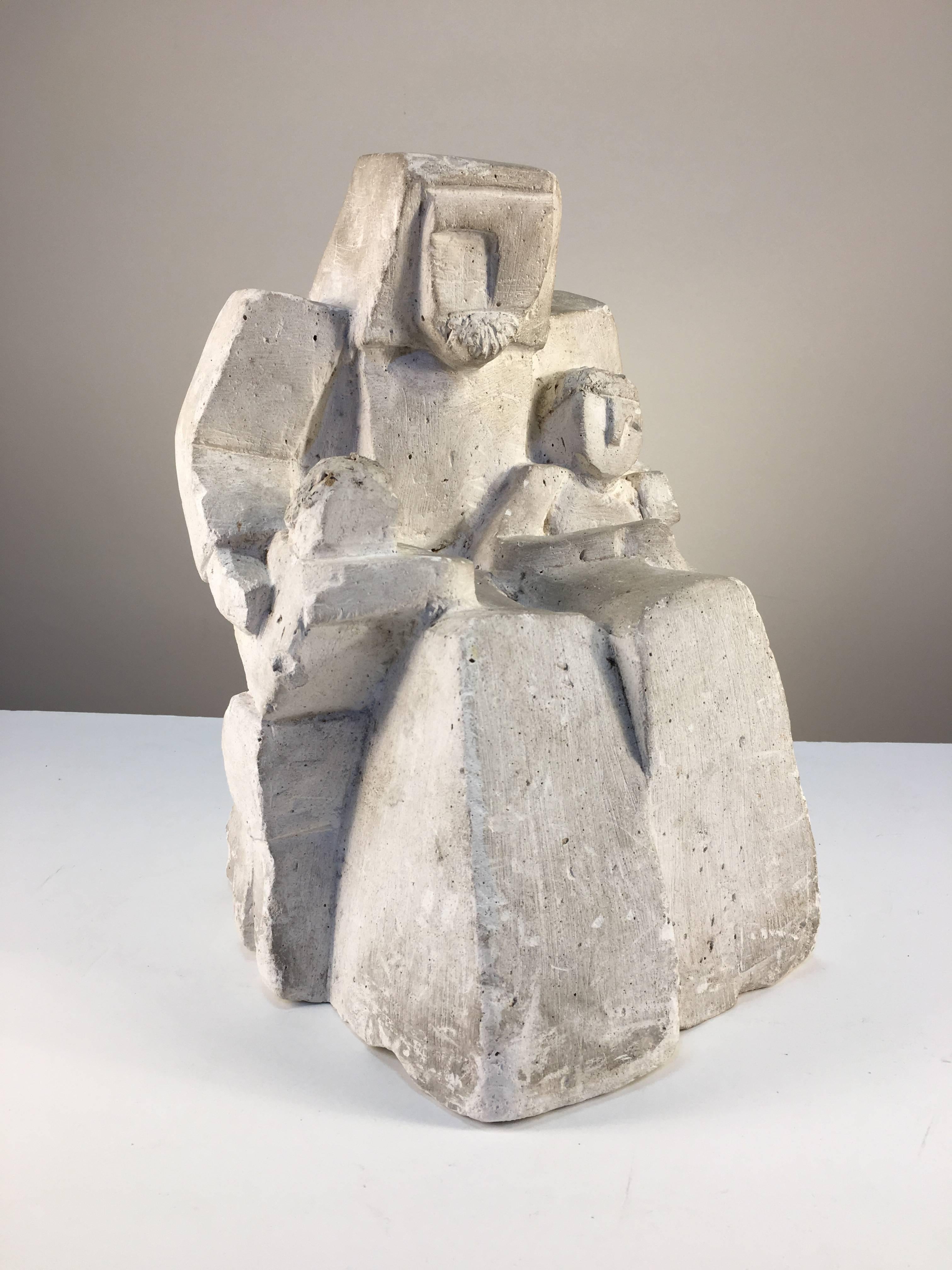 An interesting Cubist style figurative sculpture of a seated man with children, perhaps representing the Christ, carved from a block of chalk, circa 1940s.