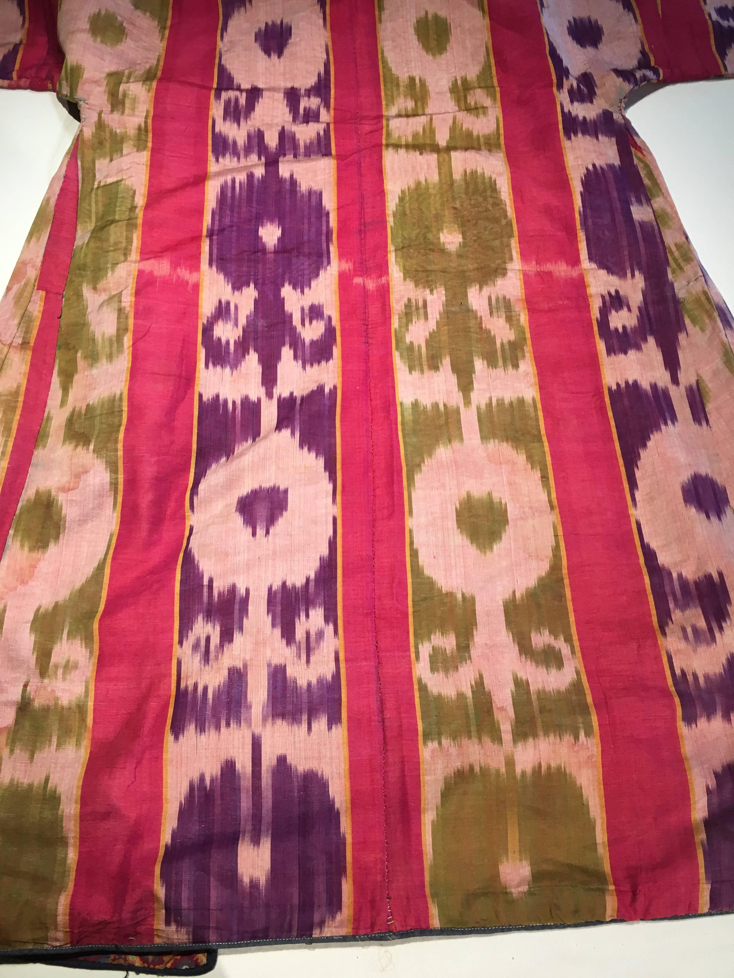 A 19th century Uzbek ikat robe in silk and cotton, in purple, green and red, with an early printed fabric lining.