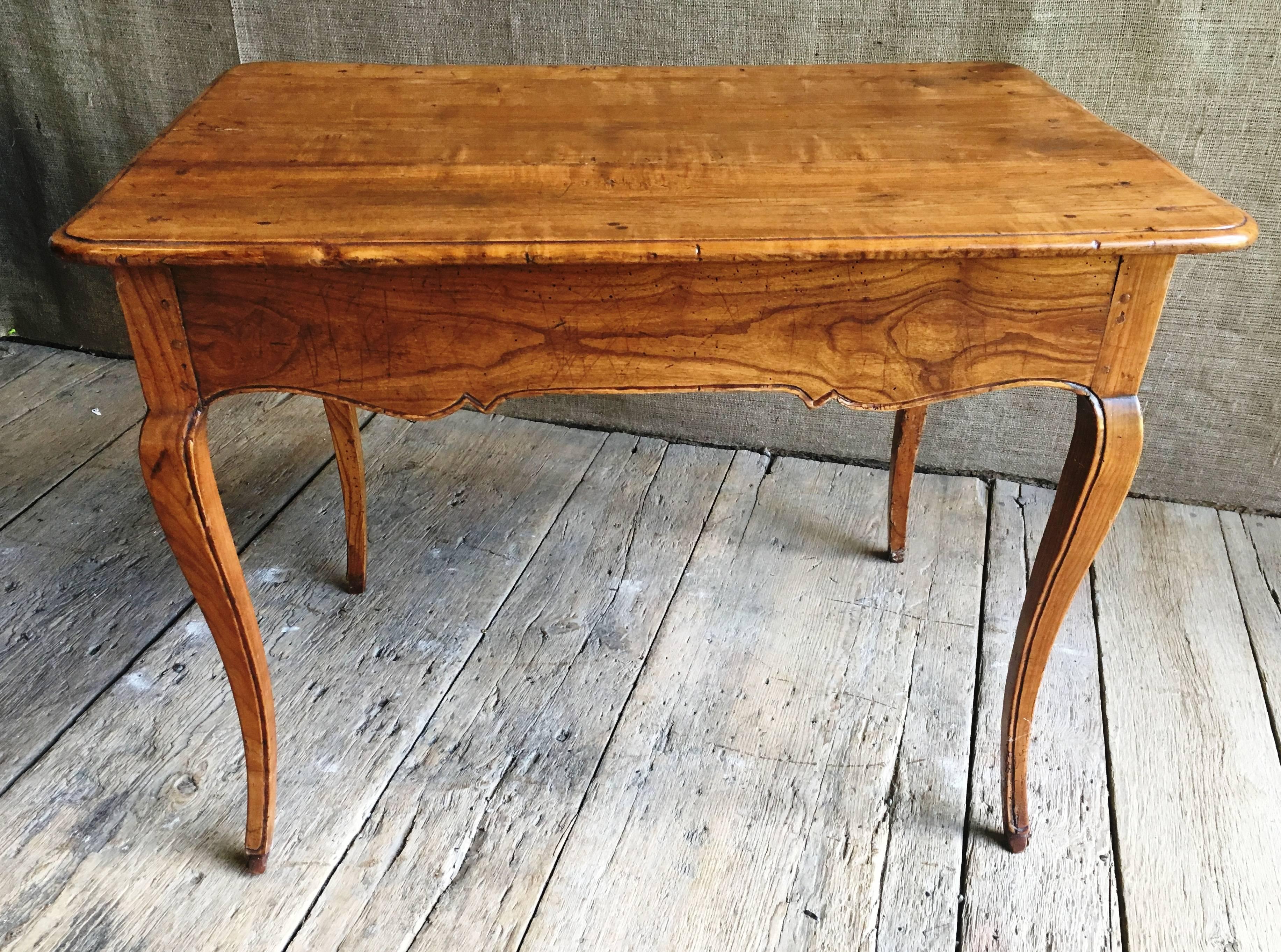 A very nice Louis XV period side table in fruit wood, circa 1760, with graceful cabriolle legs, scalloped apron and a single drawer. The table is from the estate of Pierre Moulin, founder of the Pierre Deux chain of stores and author of French