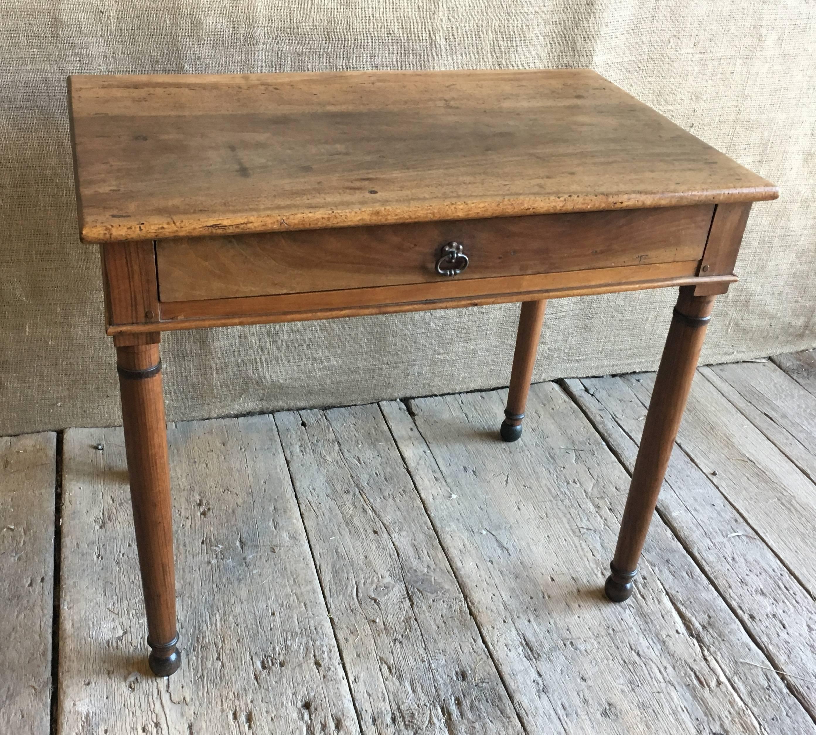 A nice French Directoire side or writing table in walnut, circa 1800, with a long drawer and turned legs with ebonized details. Finished on all sides.
