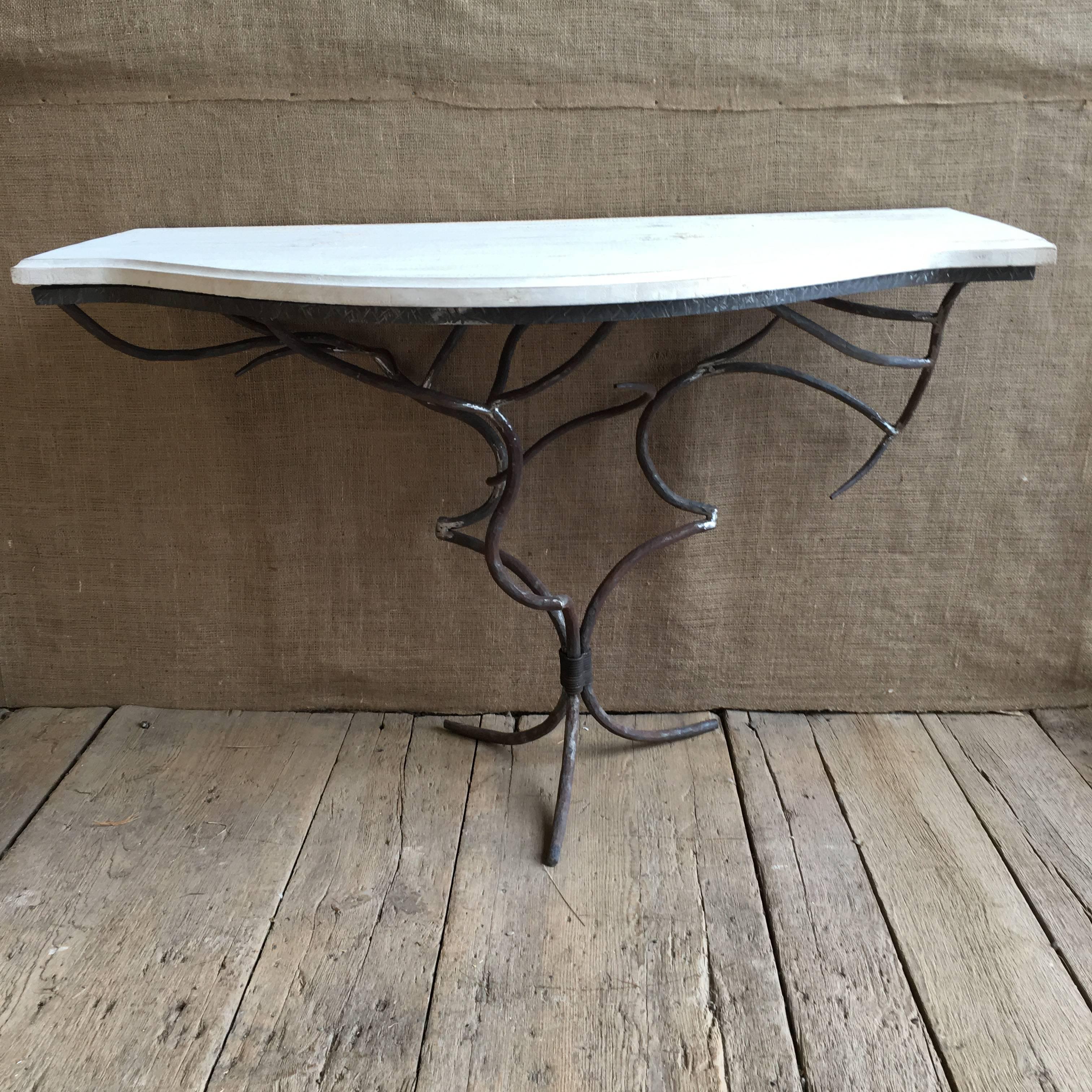 A hand-sculpted wrought iron console table in the form of branches, with a painted wood top, 20th century.