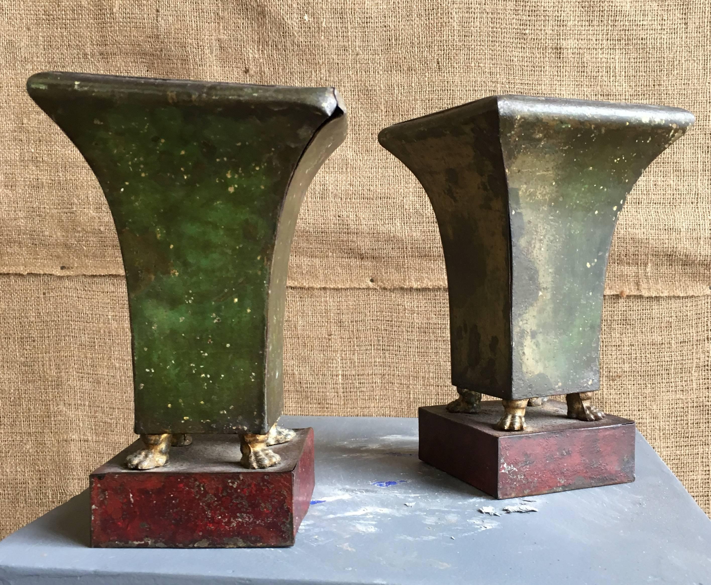 A pair of small tole Jardinière with interior liners, French Empire period, circa 1800, the upper vase in older green painted finish on paw-form feet on a red painted base.