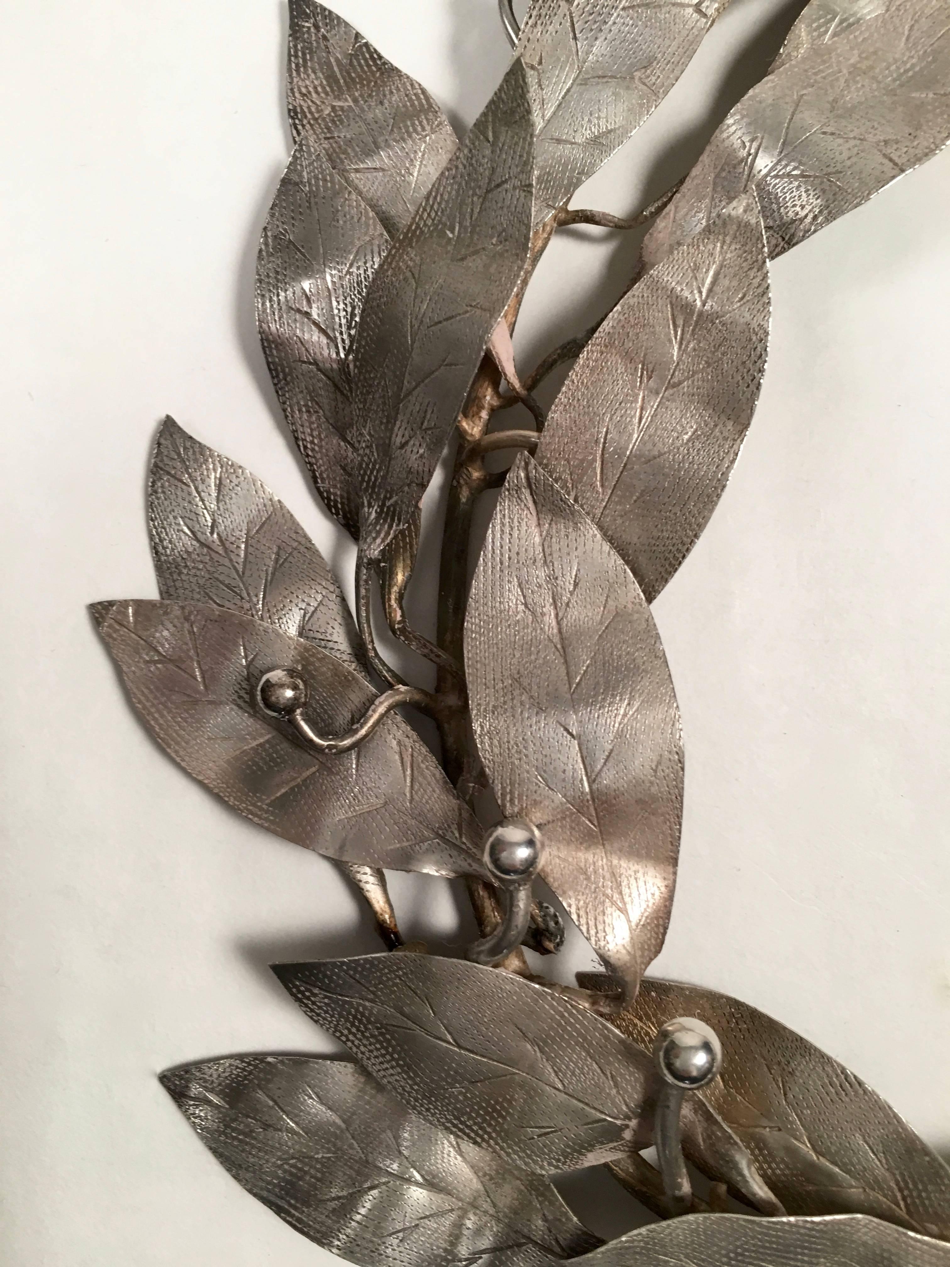 A decorative silver plated, naturalistically modeled ribbon-tied laurel wreath, originally made as a drama trophy for 'perfection and unity in pronunciation,' of the Flemish language, awarded by the Young Flemish People's Organization, circa 1904,