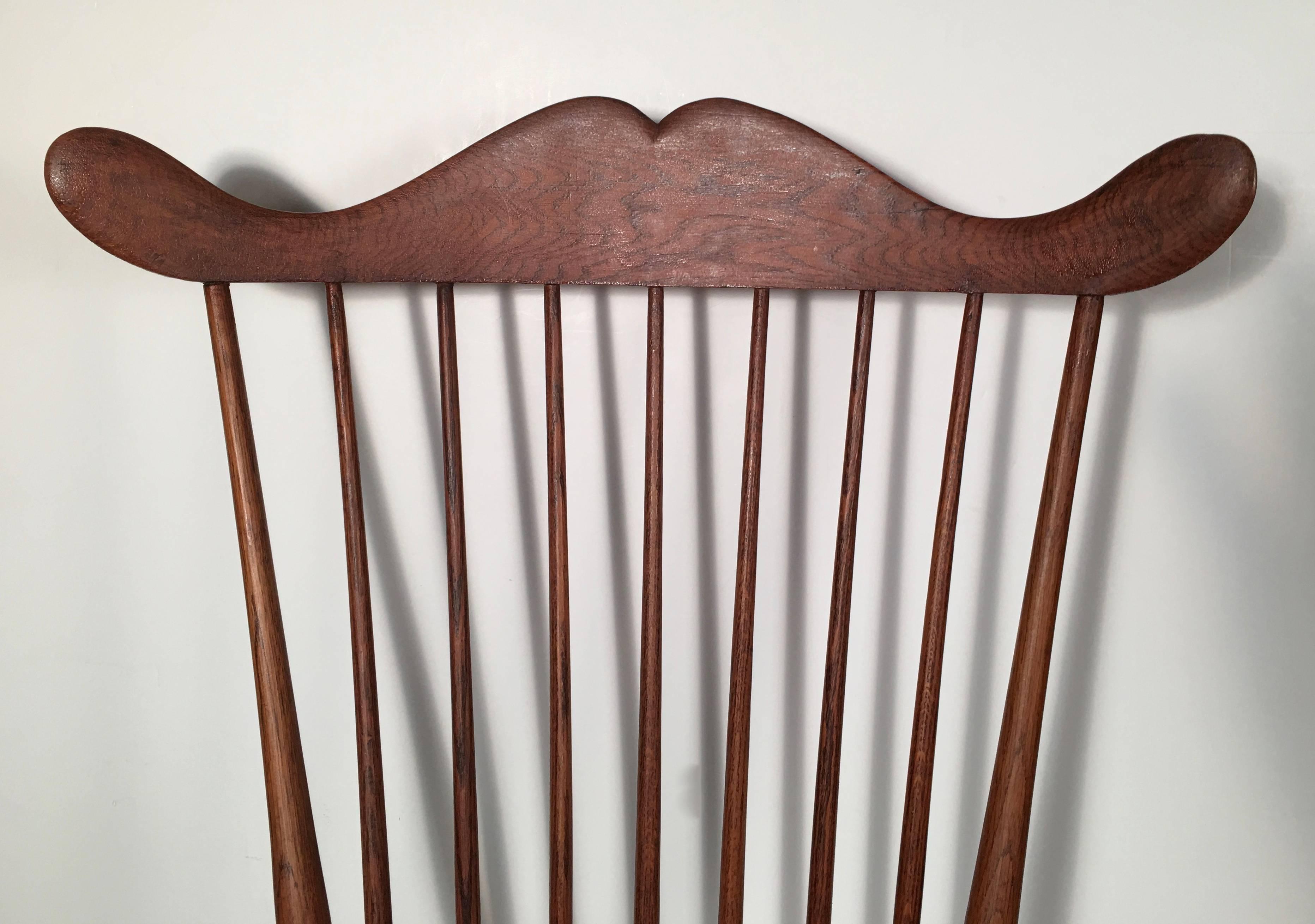 An uncommon and wonderfully shaped comb back New Hampshire Windsor chair, 19th century, the exaggerated, sculptural, serpentine crest rail above turned and swelled supports over the shaped seat, raised on turned, swelled and incised splayed legs,