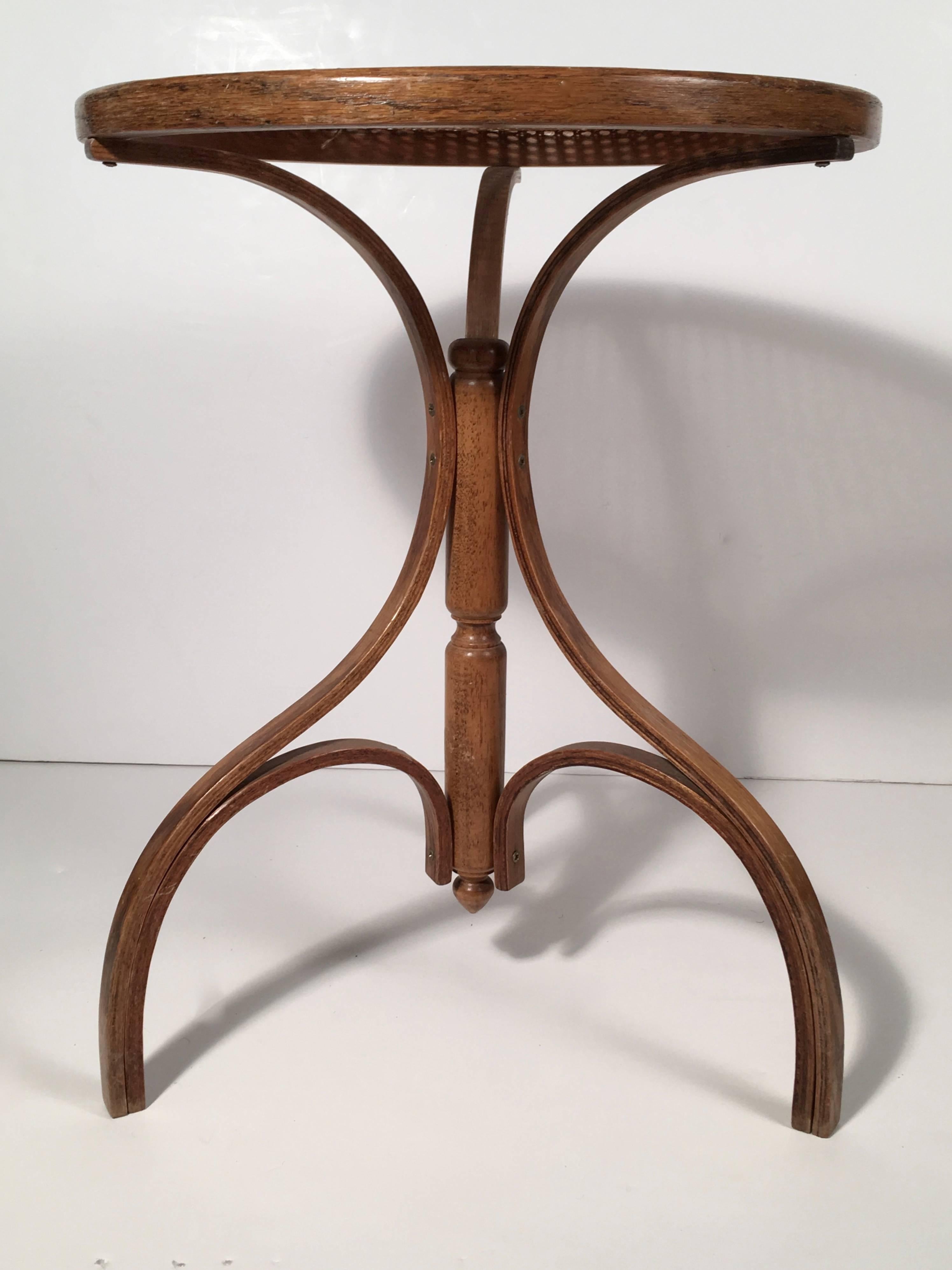 A small bentwood and caned occasional table, the circular caned top, over a turned and bentwood tripod base.