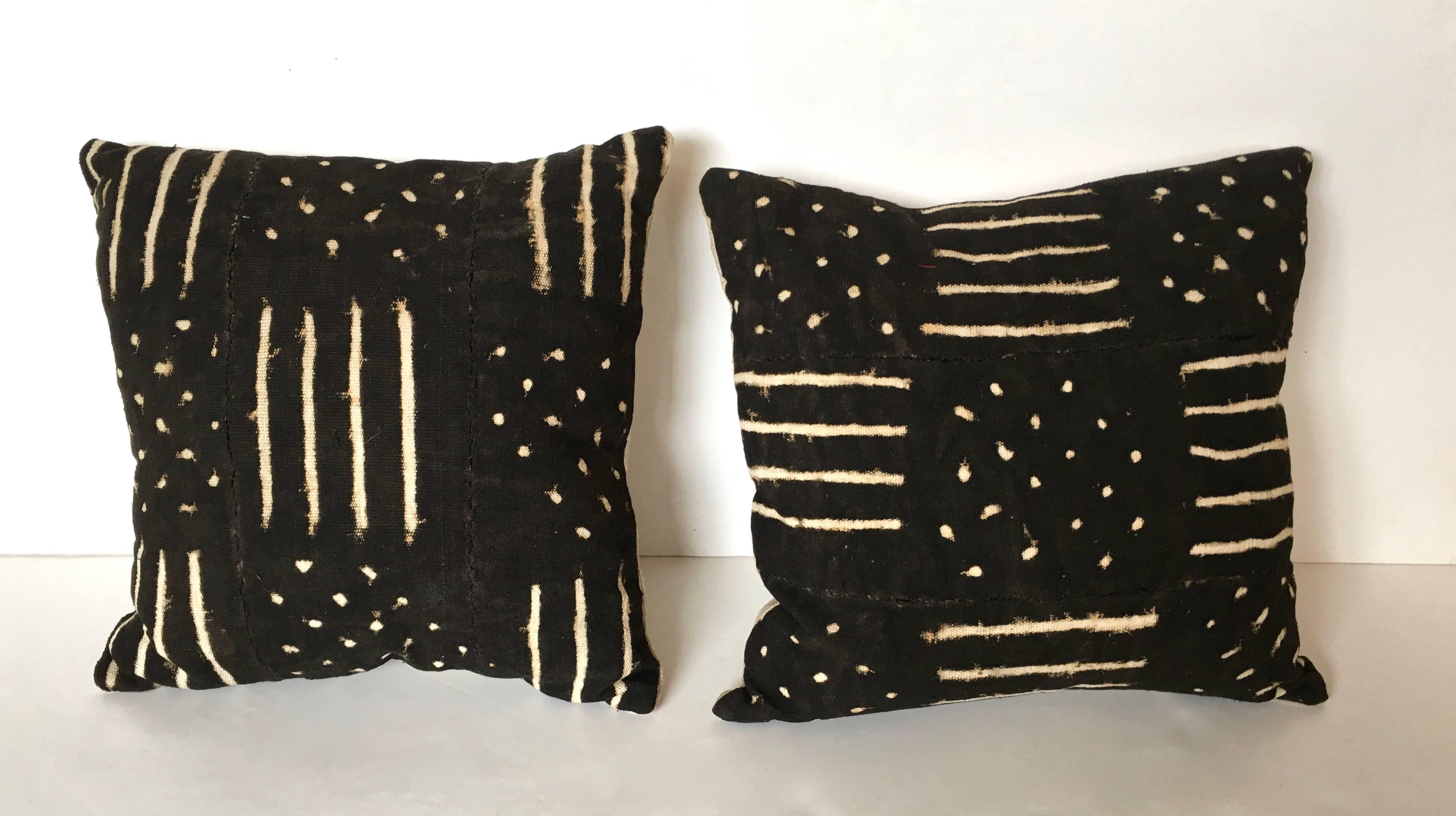 Handmade African mud cloth pillows, in graphic checkerboard pattern consisting of parallel lines and dots, from Mali, made by the Bambara tribe, according to traditional methods, in narrow strips of cloth which are sewn together to make larger