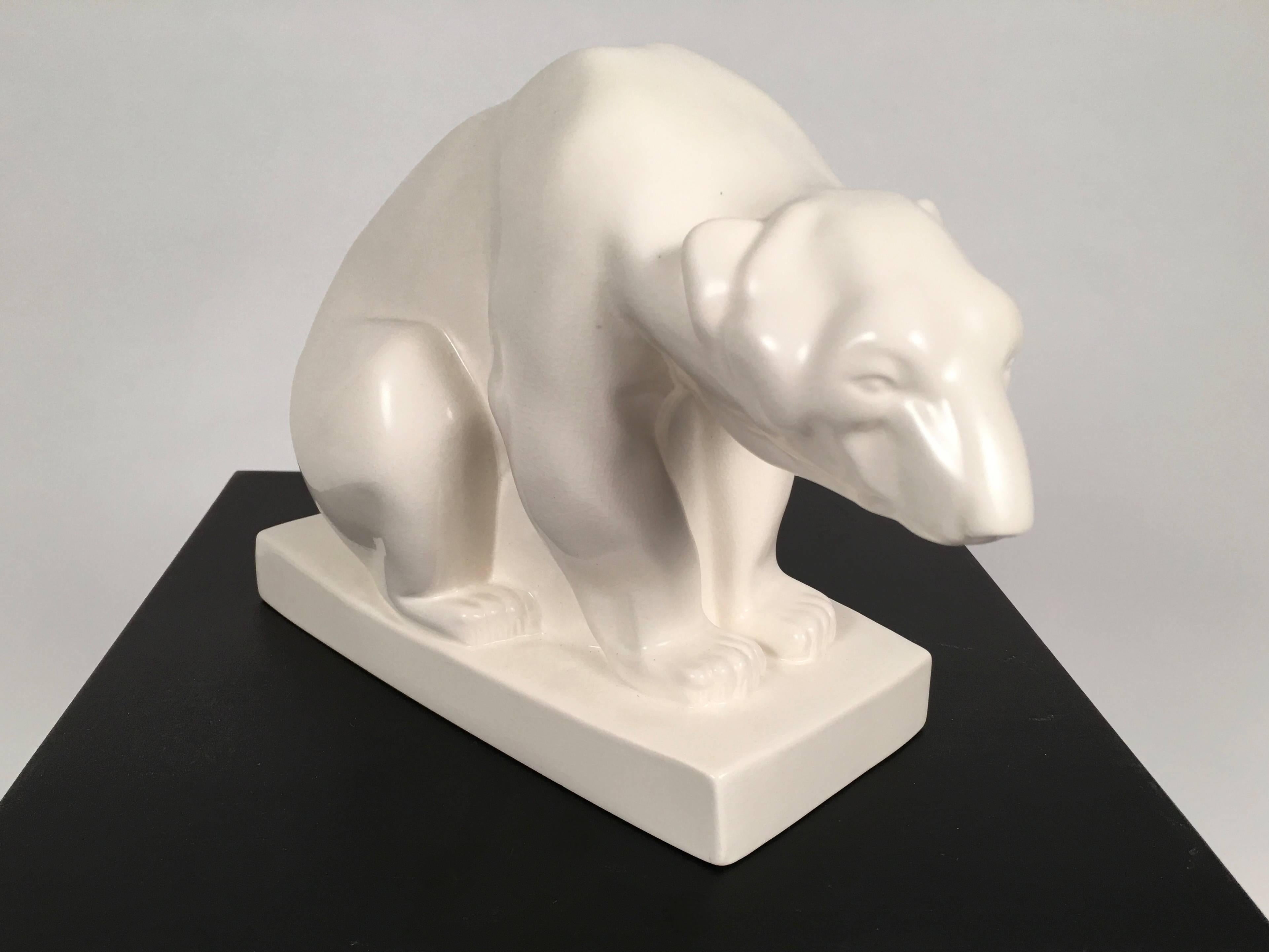 A Wedgwood moonstone pottery sculpture of a polar bear, beautifully modeled in satin, creamy white glazed ceramic designed by John Skeaping in 1927, made by Wedgwood and Sons, Barlaston, England, circa 1950. Signed with incised signature on back of