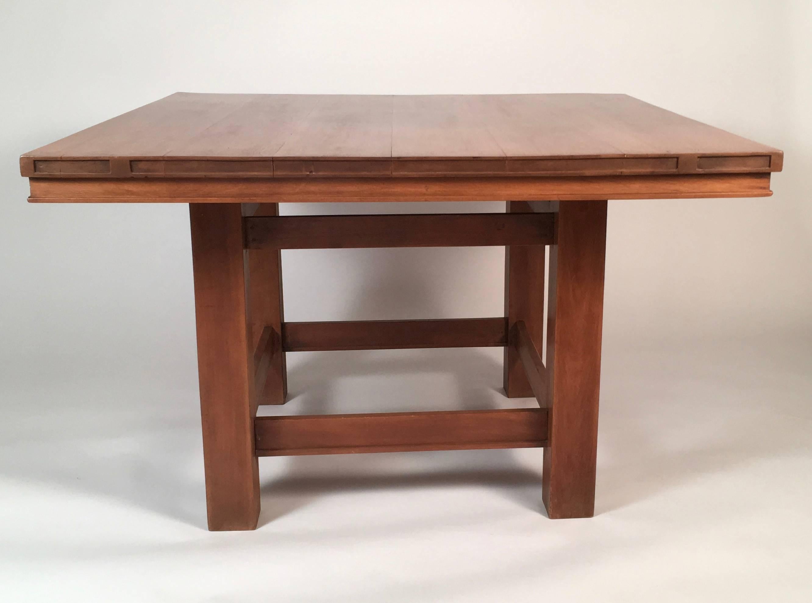A beautiful Arts and Crafts period Prairie School table, attributed to Frank Lloyd Wright, of square form, the frieze with characteristic horizontal, Japanese-inspired shallow carved geometric decoration, over four square section legs joined by