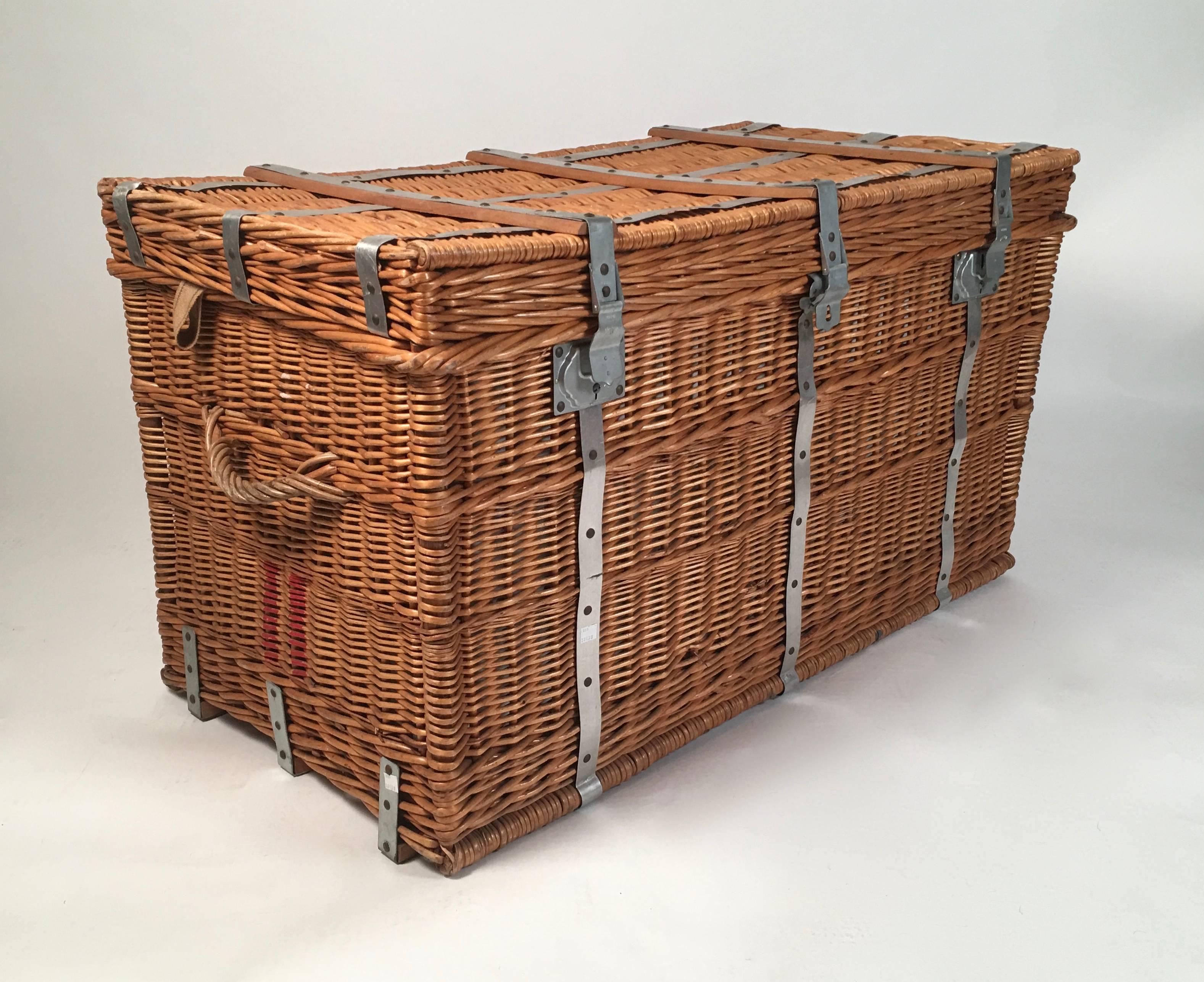 A large rectangular French wicker trunk with steel strap mounts, made by Bellbonn with two wicker strap handles and canvas straps on the interior of each side to keep cover up when open, painted with the number 11 in red on each side, the interior