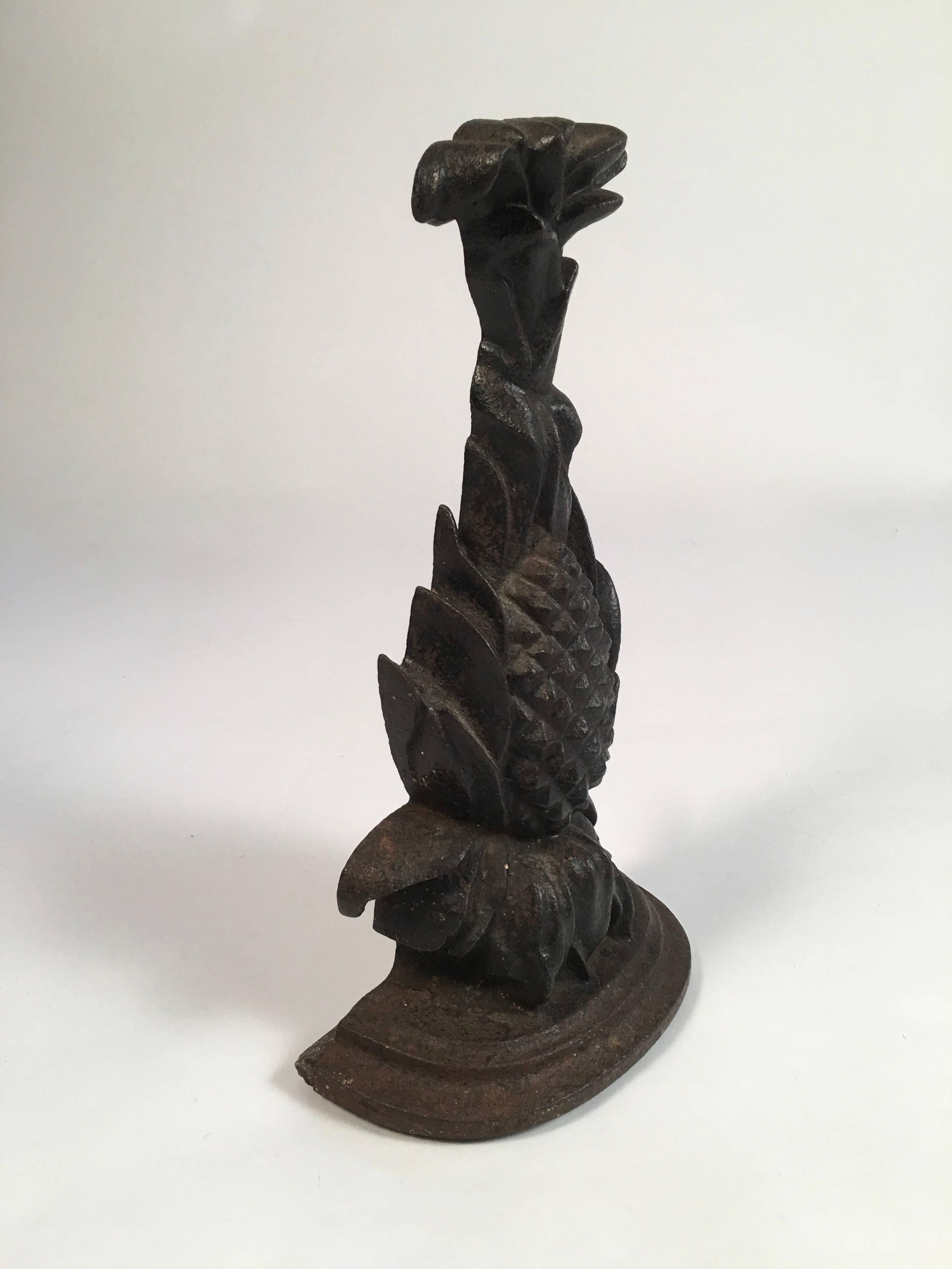 A cast iron pineapple-form doorstop, the semicircular base supporting a pineapple with leaves issuing from the top, American, circa 1860s-1880s. Good weight and size, and wonderful, functional decoration.