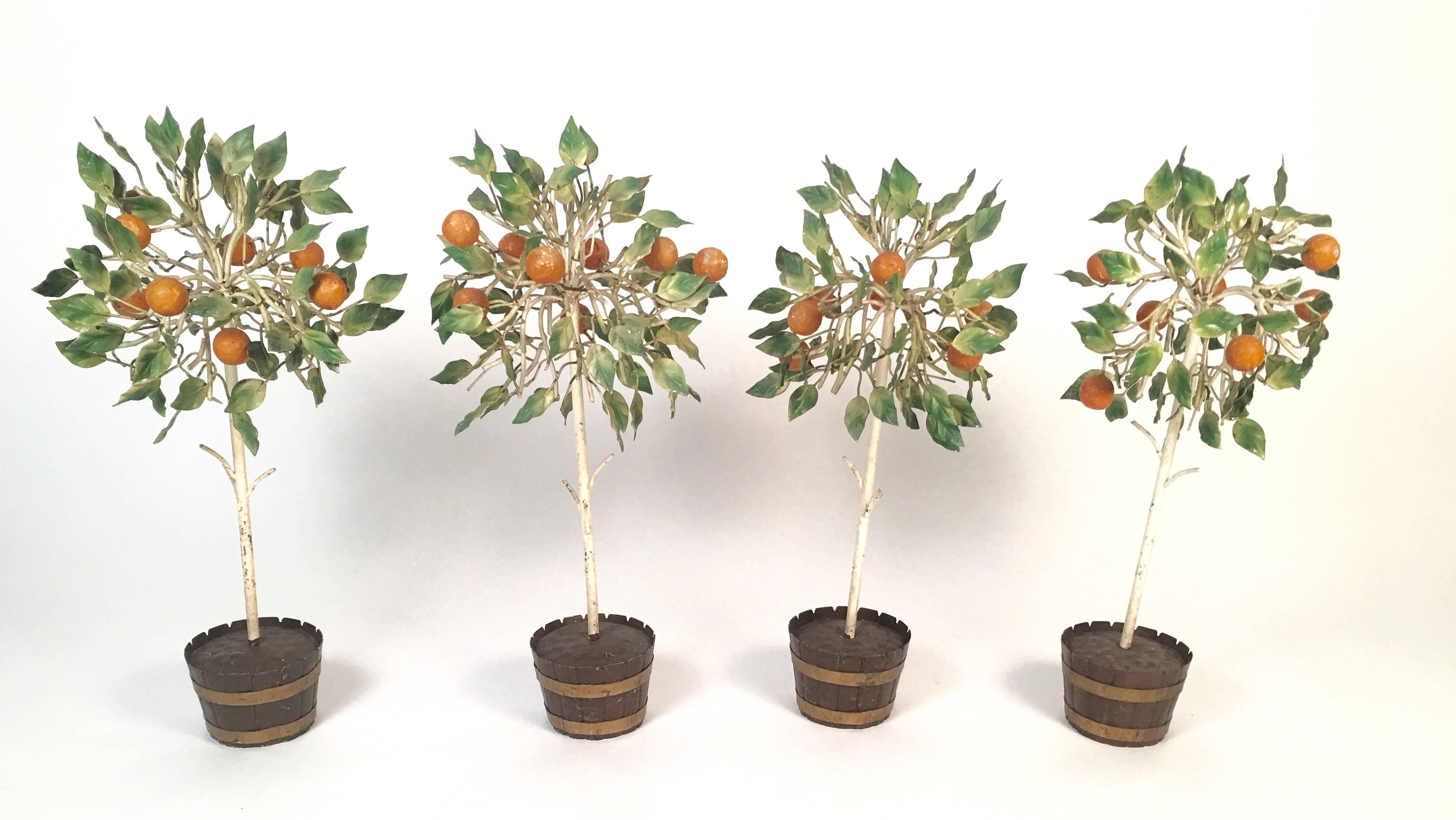 A set of four vintage decorative Italian tole orange trees, the branches in white painted metal with variegated green painted leaves in brown metal barrel-like planters with wood slats, filled with bumpy metal resembling soil. Beautiful on a mantel,