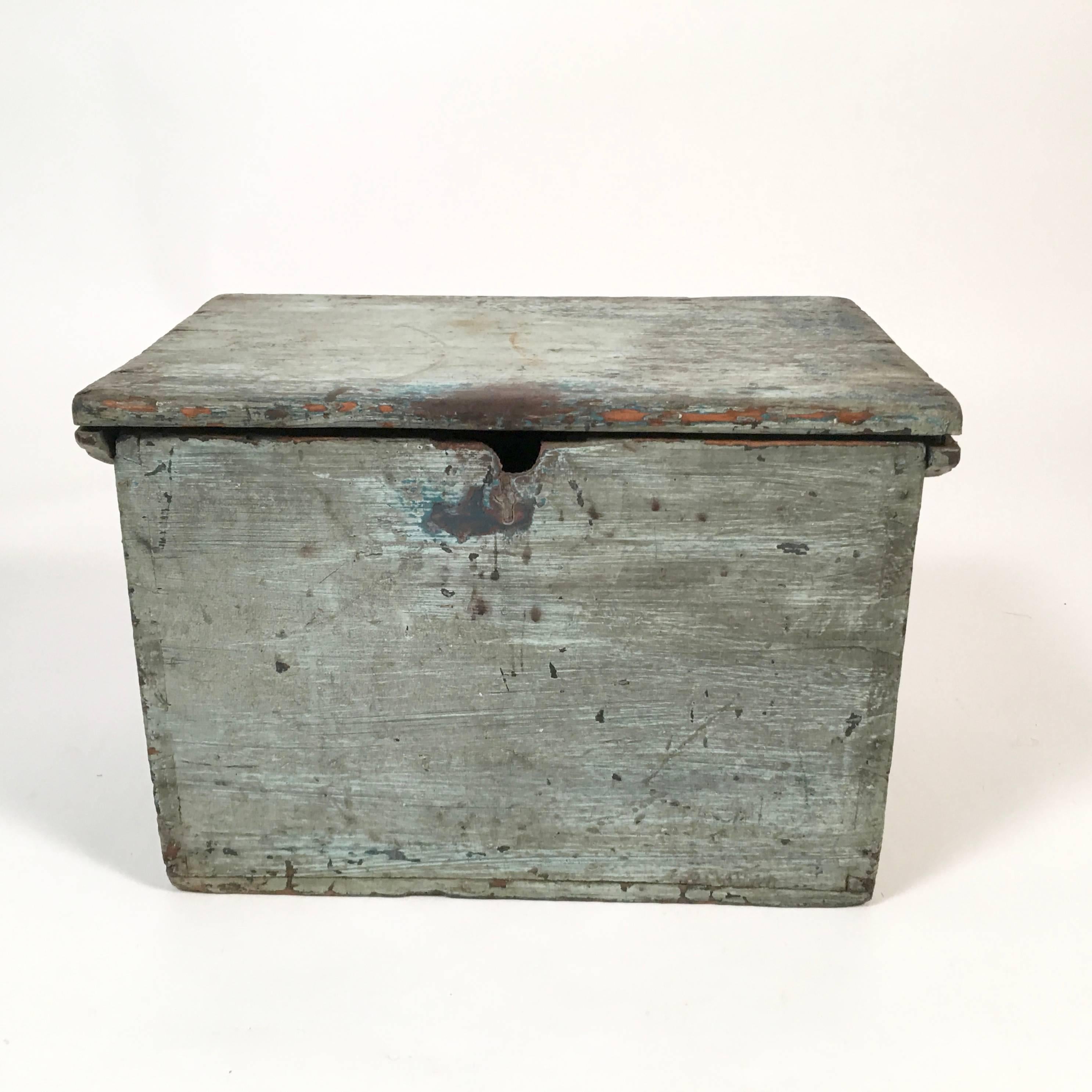 A Primitive blue country box from Maine with wonderful color and patina, in pine, with several old layers of blue paint and iron carrying handles on the side. Functional for storage of remote control devices or other things and great as a decorative