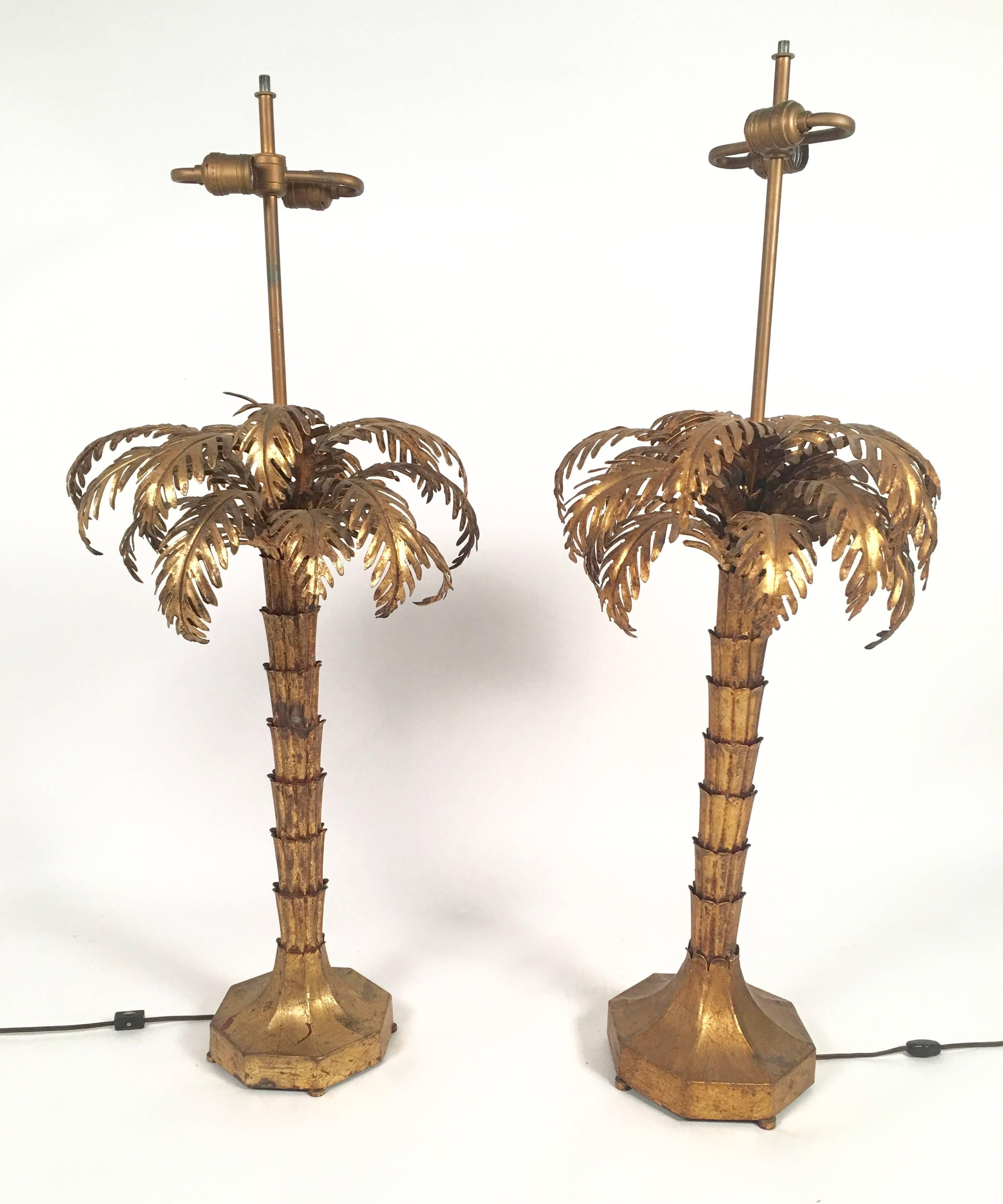 A stylish matched pair (very similar, but not identical) of Mid-Century Italian gilt metal palm tree form lamps, the palm fronds arching over a tapering fluted and segmented trunk on a sloped hexagonal base raised on small ball feet. These lamps are
