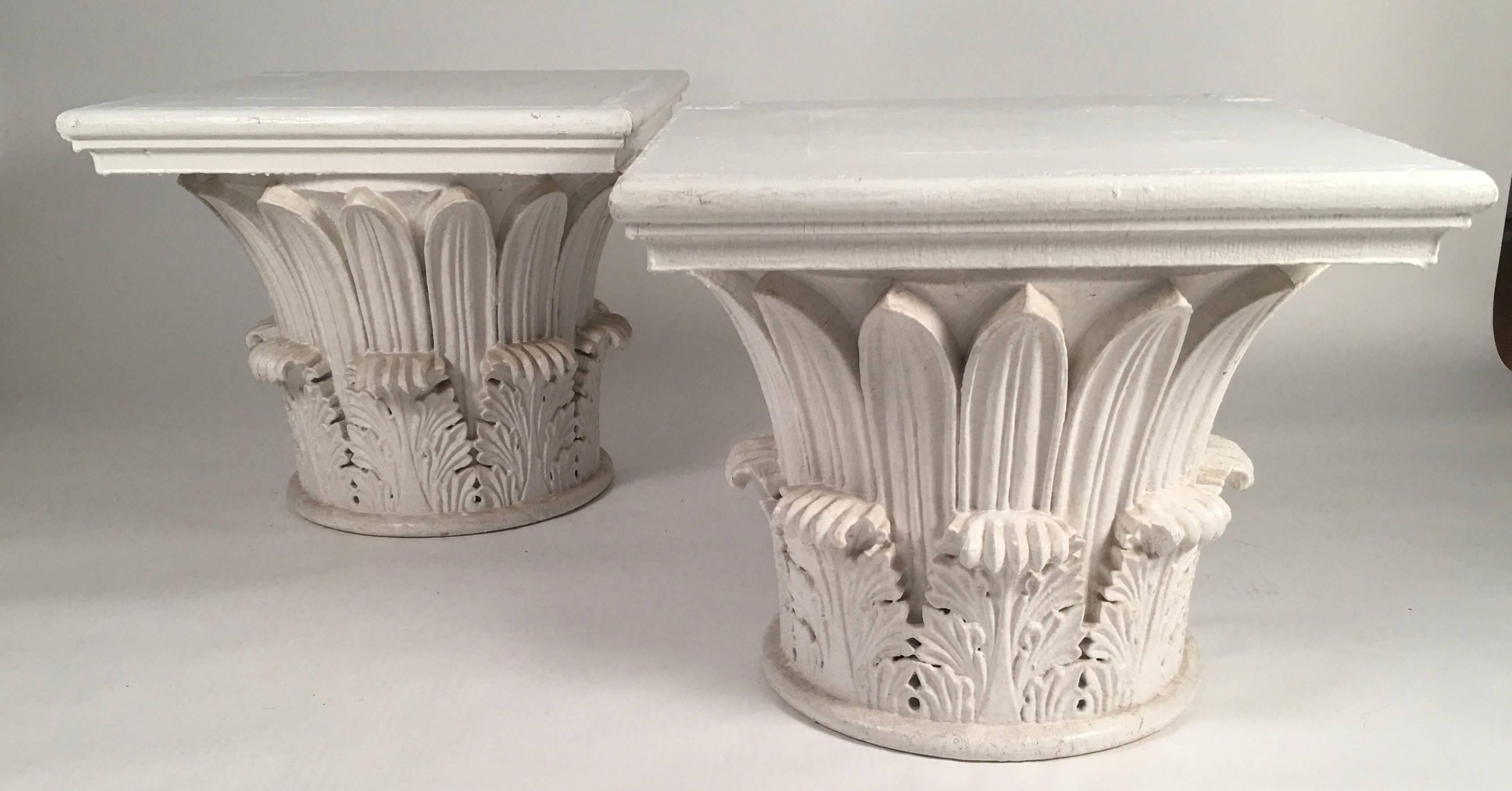 A pair of large 19th century neoclassical carved wood and white painted column capitals in the Corinthian Tower of the Winds order, featuring a single row of palm leaves above a row of acanthus leaves. These architectural elements would make