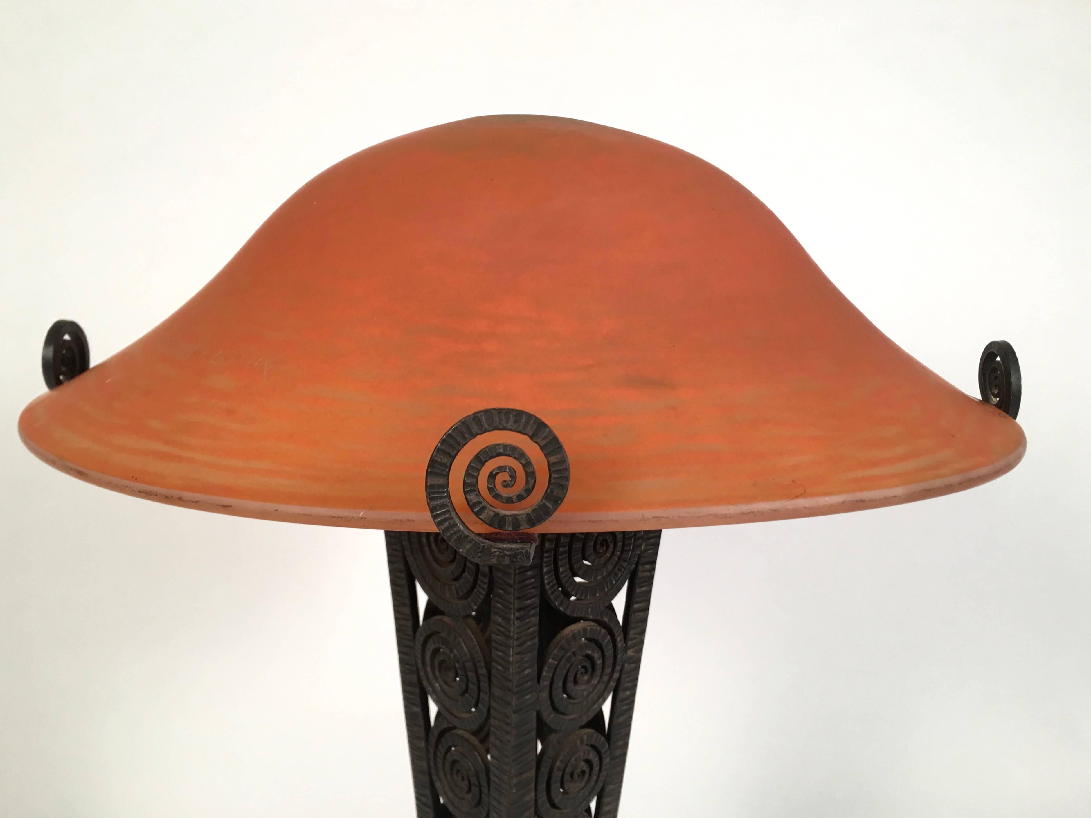 A fine quality French Art Deco period table lamp, the wrought iron base of tapering square form with open, textured spiral design leading to a spreading quatrefoil shaped base, in the manner of French ironsmith Edgar Brandt, the beautiful thick