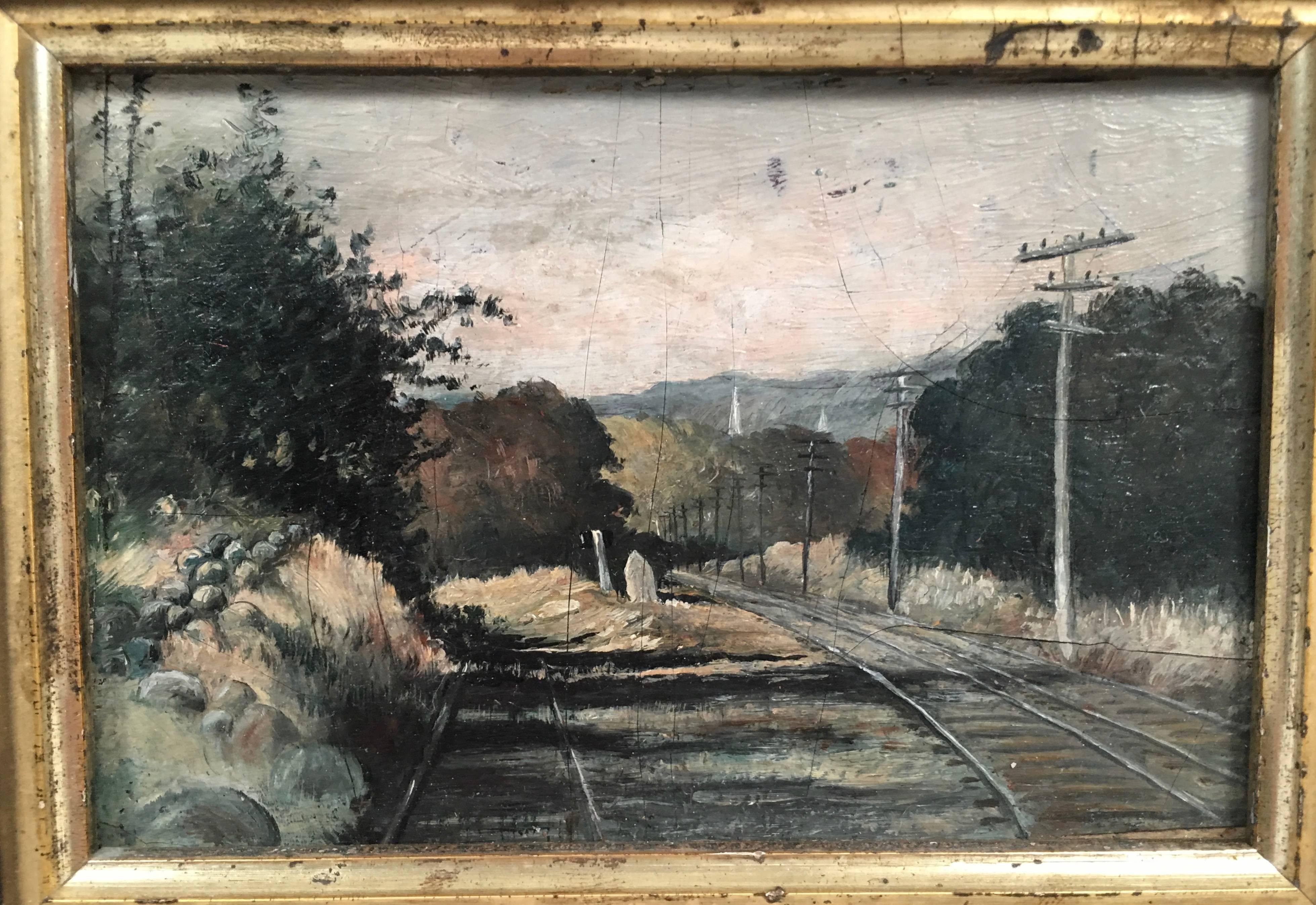 A beautifully rendered, unusual small, late  19th century oil on board painting depicting railroad tracks and telegraph poles in a rural setting with mountains and a church spire in the background, in its original ebonized oak frame with gilded