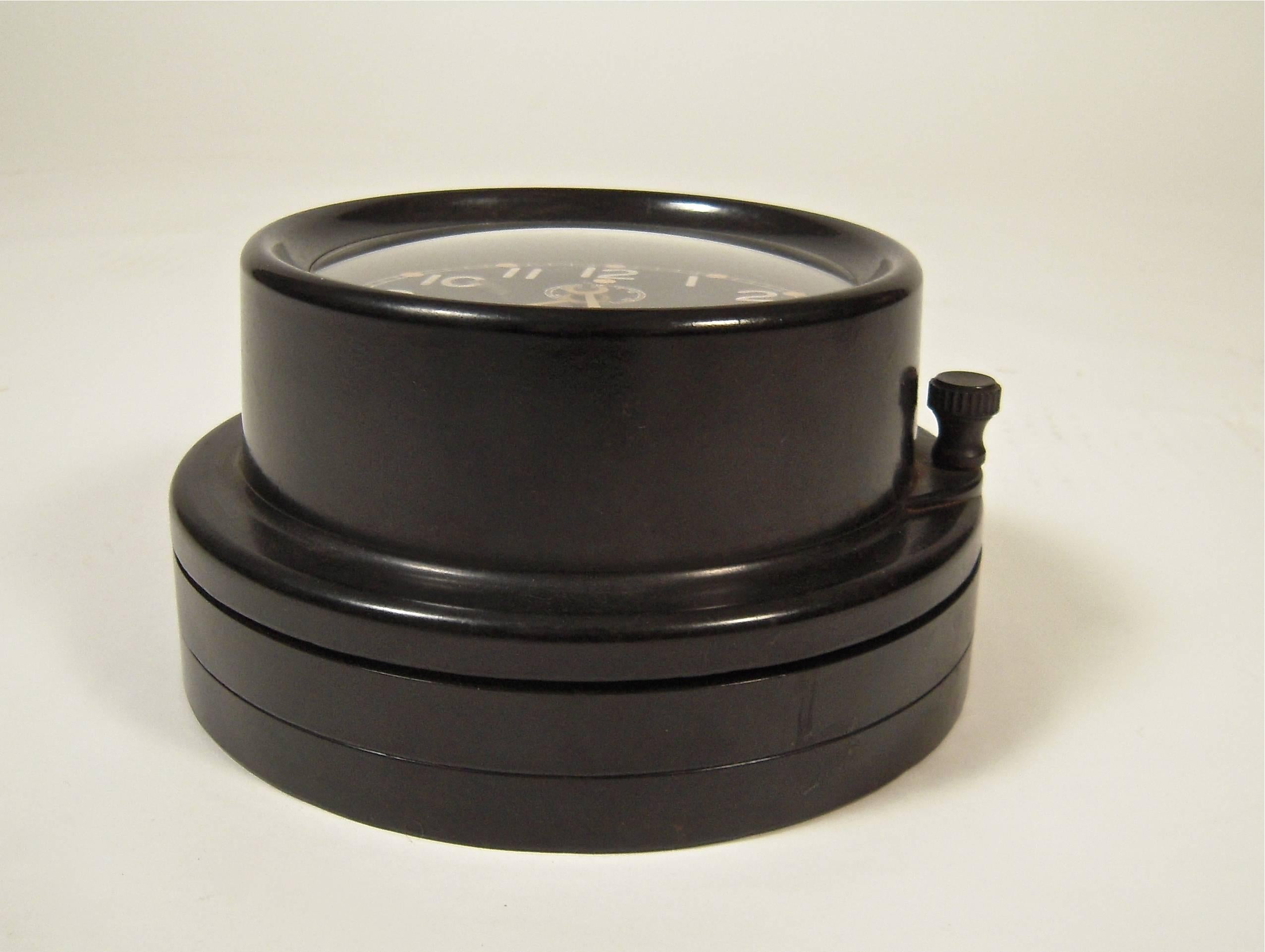 A graphic, Chelsea U.S. Navy Mark one deck clock, Boston, circa 1942, No. 41707, with a 6 inch black dial with white Arabic numerals, on a stepped base, with 8 day, time-only rear wind and set movement, in a hinged black phenolic case. Runs well and