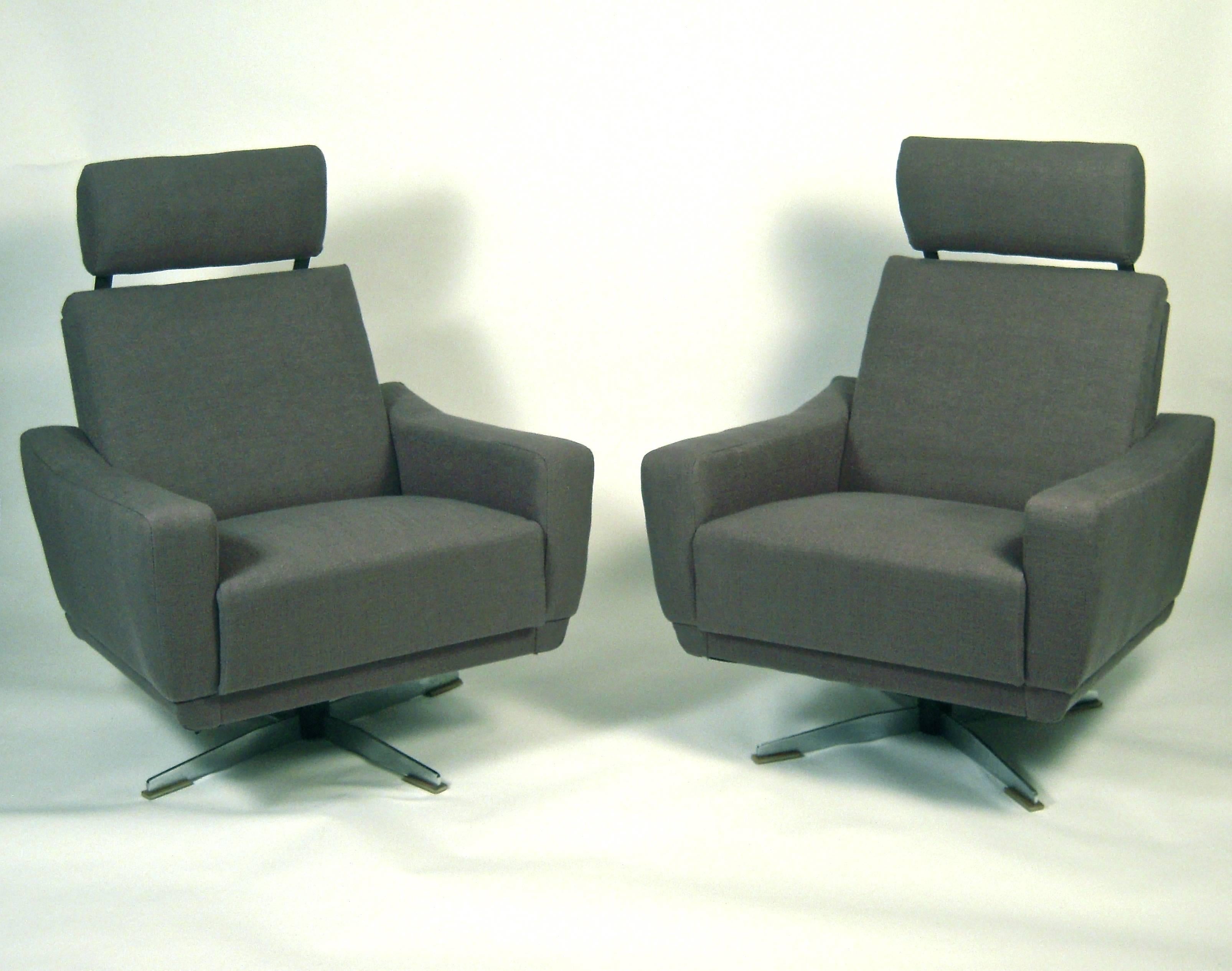 A pair of unusual, versatile and very comfortable German Mid-Century Modern swivel armchairs, with retractable headrests, which flip up from behind the back cushions, and reclining backs, newly upholstered in charcoal grey linen, on steel X-form