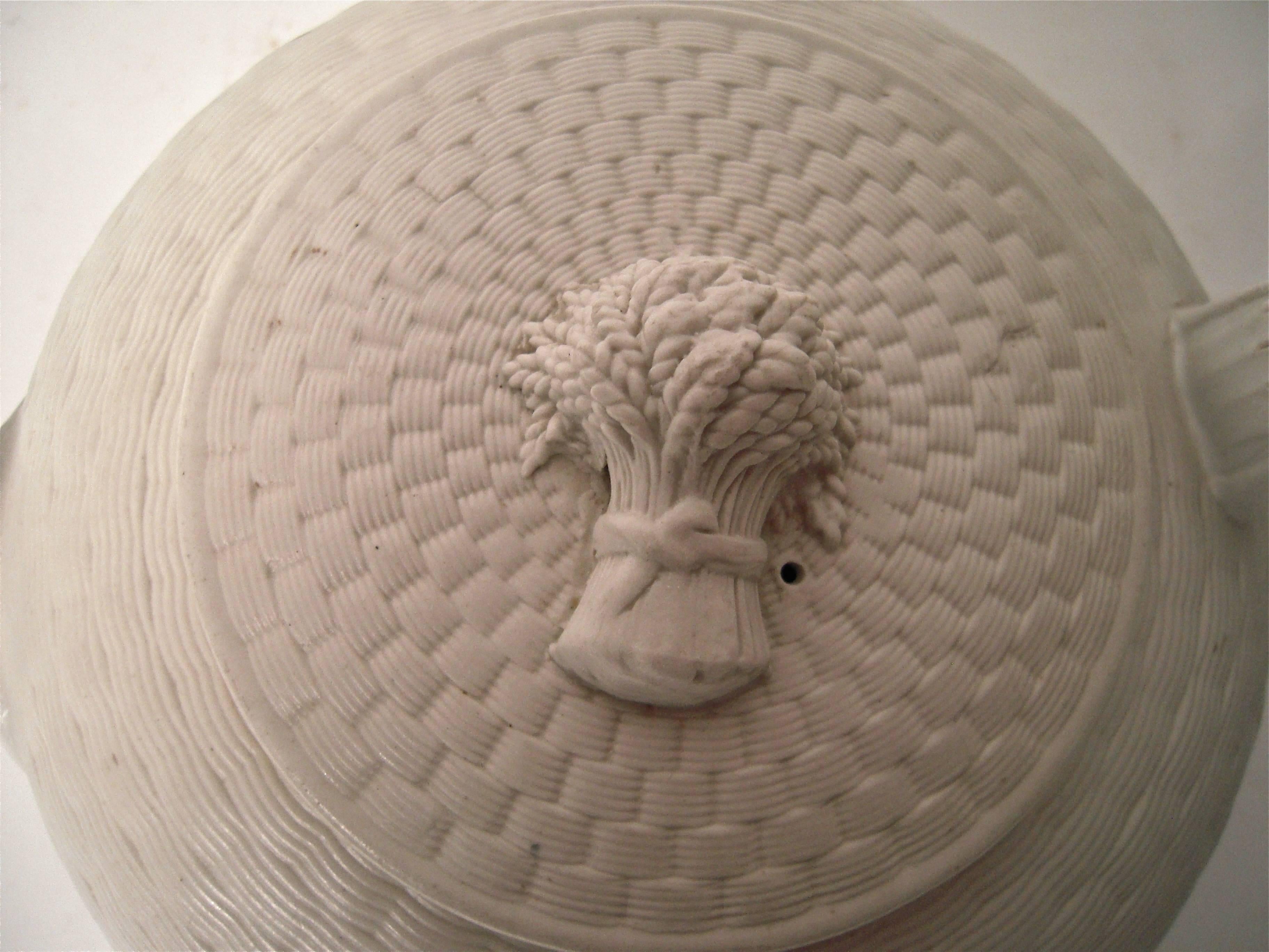 A 19th century Wedgwood white stoneware tea pot of compressed circular form, with overall basket weave decoration and sheaf of wheat finial, with acanthus leaf decoration under the spout. Impressed mark on bottom. Beautifully modeled and very