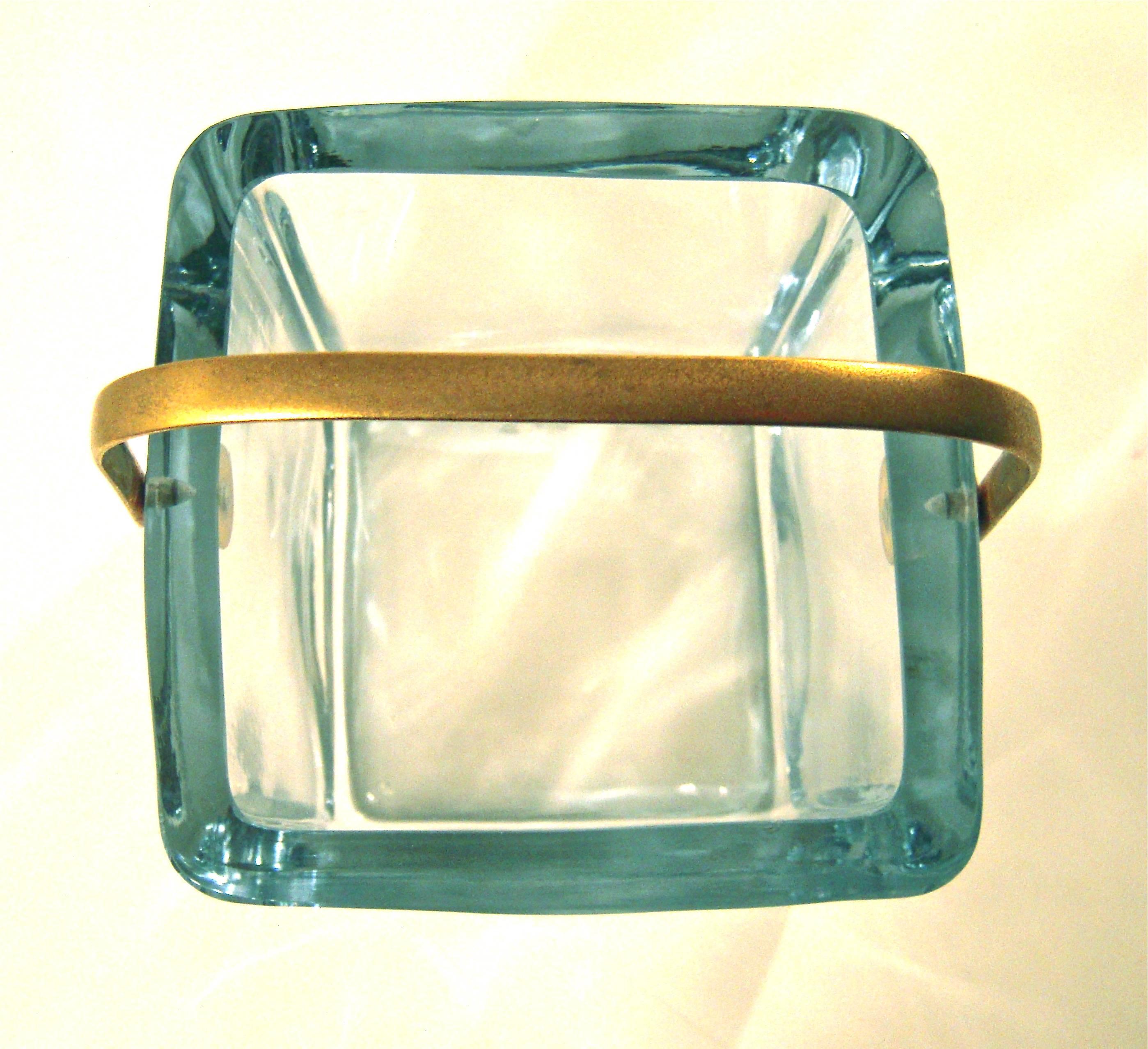 A fine quality, chic Cartier ice bucket in thick walled, pale blue Swedish crystal  of square form with curved corners and with pivoting matte gold-plated brass  handle. Etched 