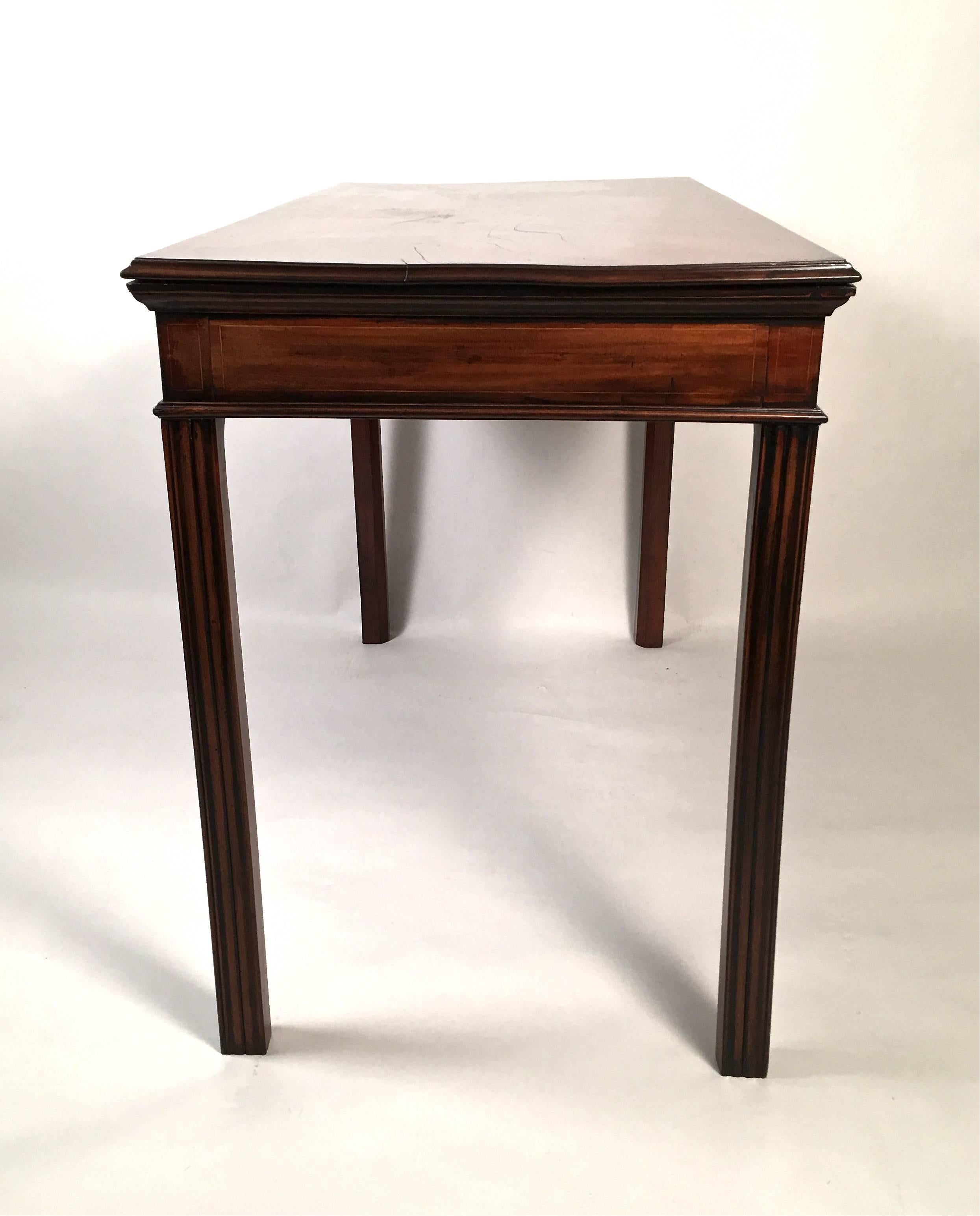 A well proportioned George III period serving or console table in mahogany, the beautifully figured rectangular top over the frieze and sides, all of which are  inlaid with boxwood rectangular stringing, raised on four square fluted legs, English