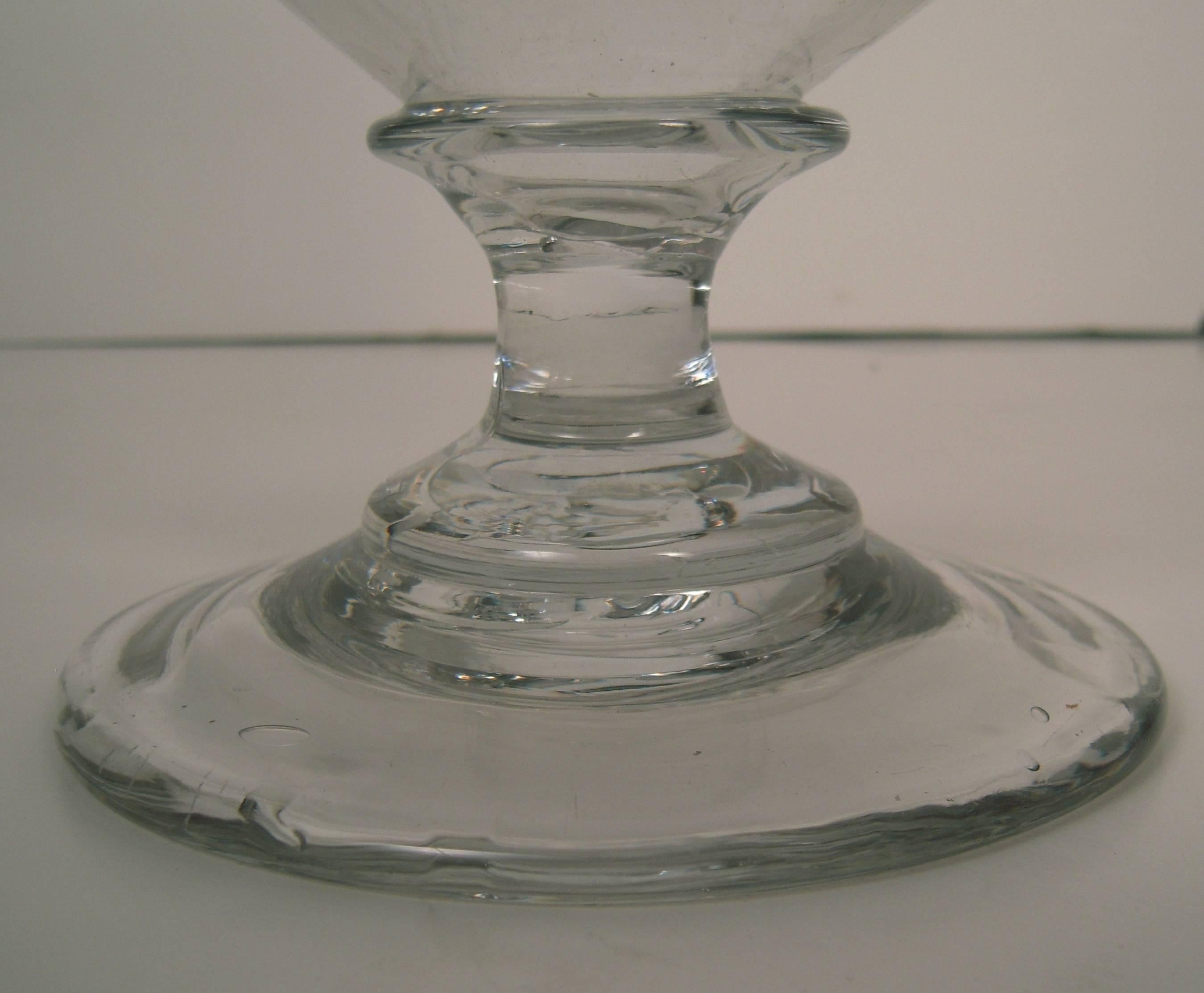 A large 19th century American colorless blown glass vase, circa 1830, of inverted bell form supported on a spreading circular base with pontil mark on the underside. 

Height: 10