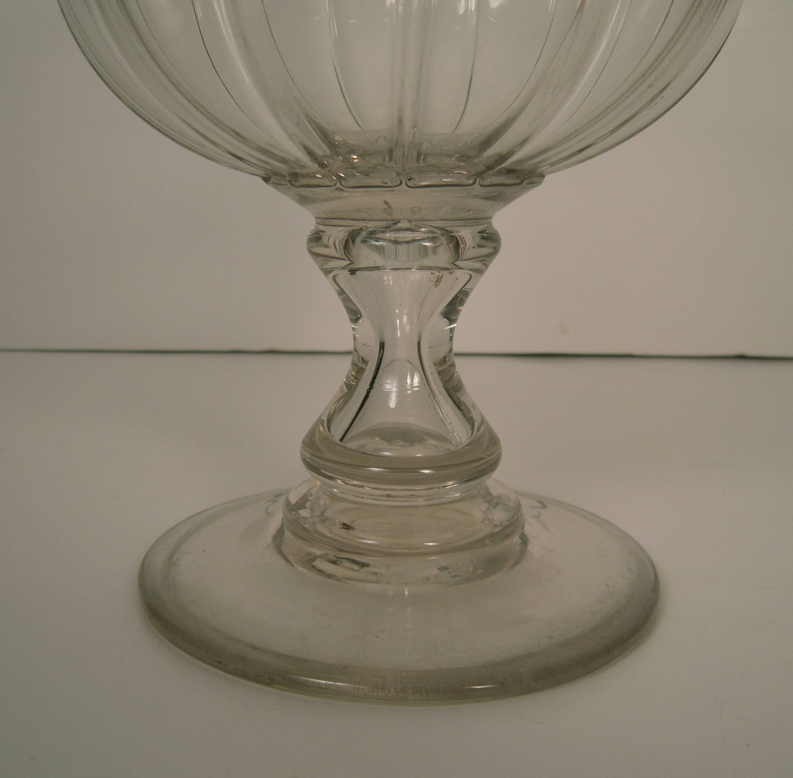 A large 19th century American colorless blown glass vase or goblet ,circa 1830, of inverted bell form with gadroooning ornament on the lower body, supported on a spreading circular base with pontil mark on the underside. Perfect for long-stemmed