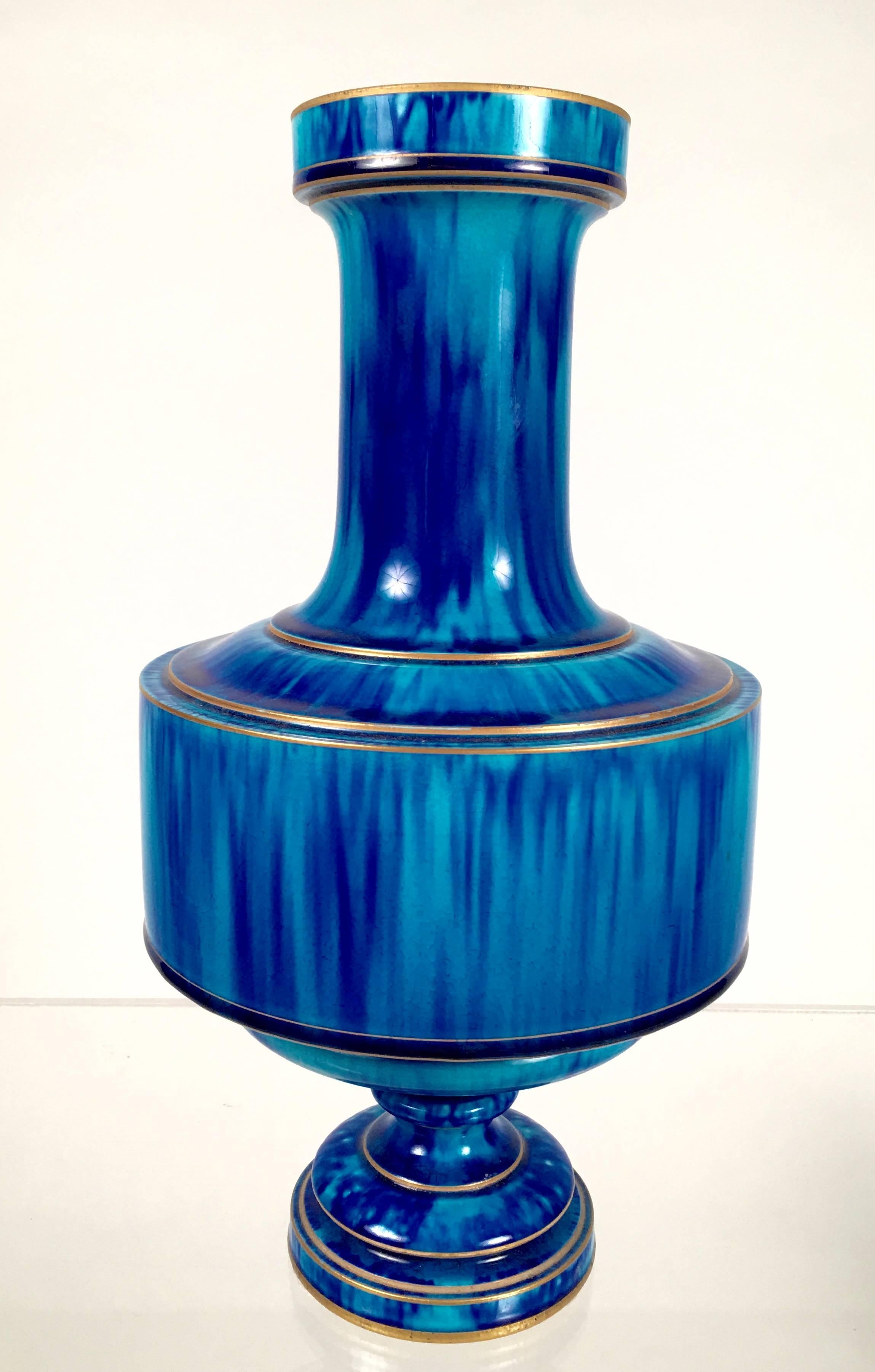 A 19th century French art pottery vase, decorated at Sevres, in mottled blue flambé glaze, the form inspired by ancient Asian bronze vases, with gilded bands. Signed on base. Fabulous color and a form which is evocative of ancient and modern design.