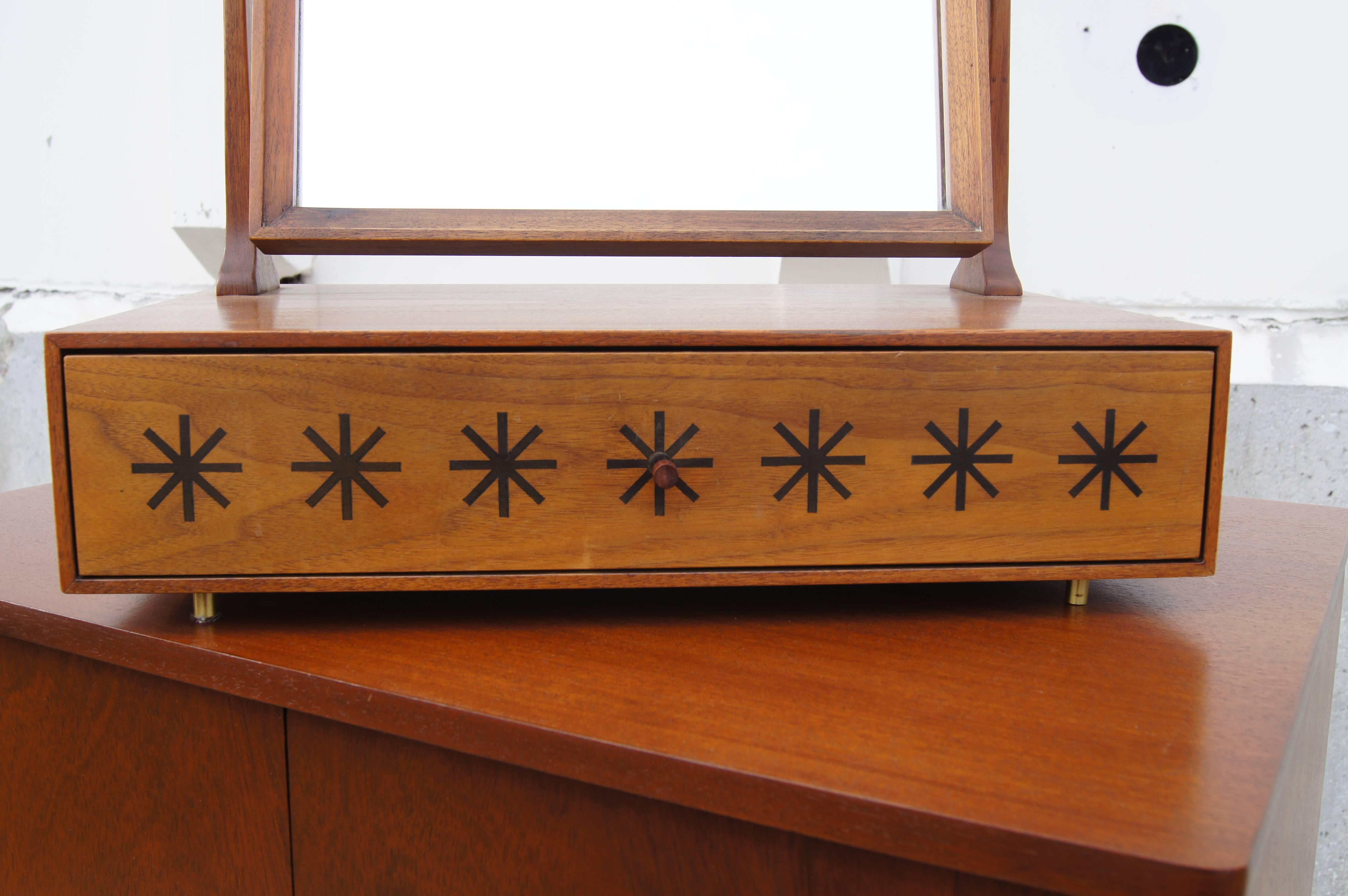 Kipp Stewart entwarf diesen seltenen Tischwaschtisch für die Directional-Linie von Calvin Furniture. Ein schwenkbarer Spiegel hängt in einem Rahmen aus Nussbaumholz über einer einzelnen Schublade, deren Vorderseite mit sieben fetten Sternchen