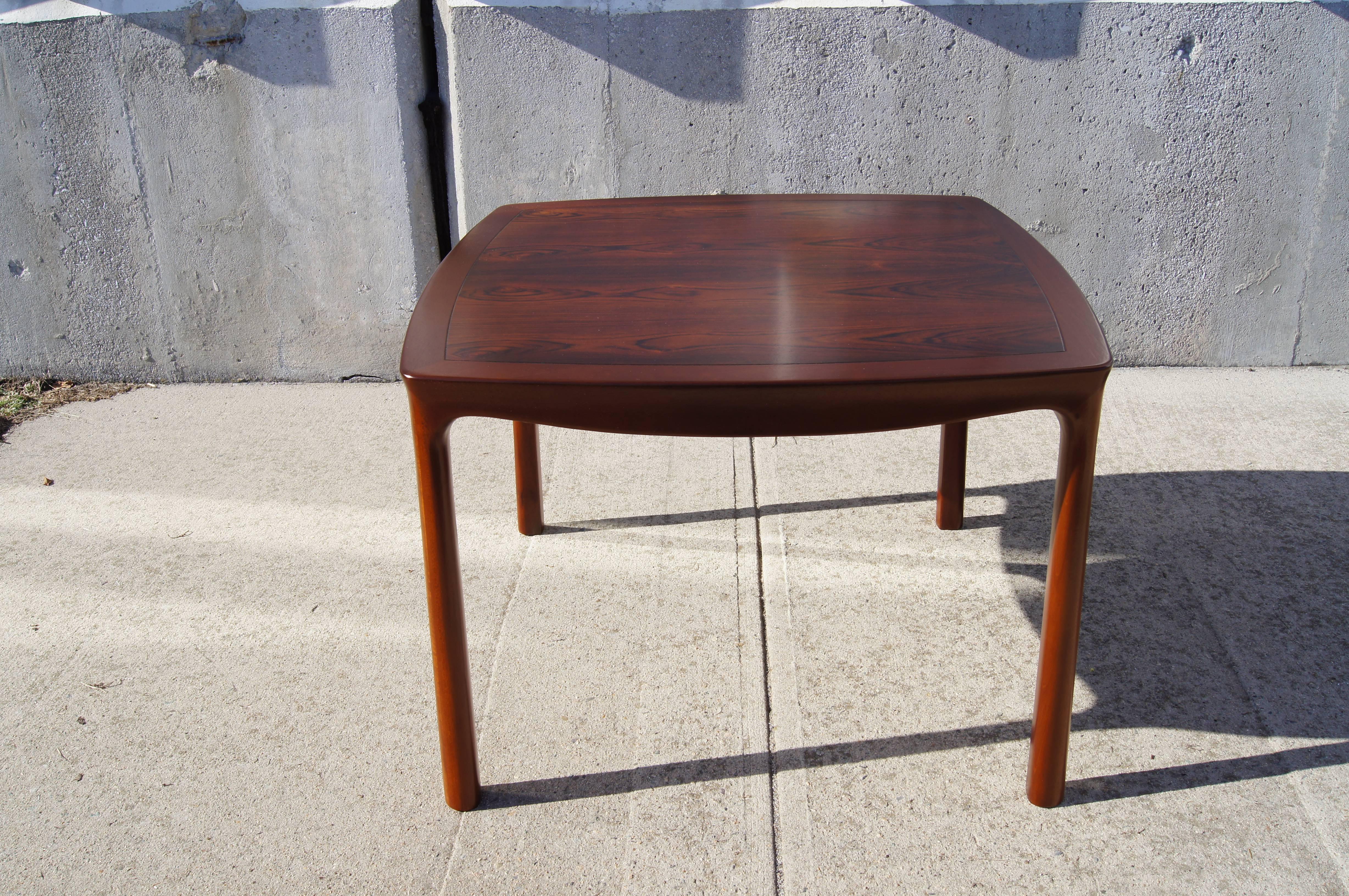 Designed by Edward Wormley for Dunbar in the late 1950s, this lovely square side table sets a deeply grained rosewood top into a mahogany frame with curved edges and gracefully shaped legs.

Dunbar label underneath.