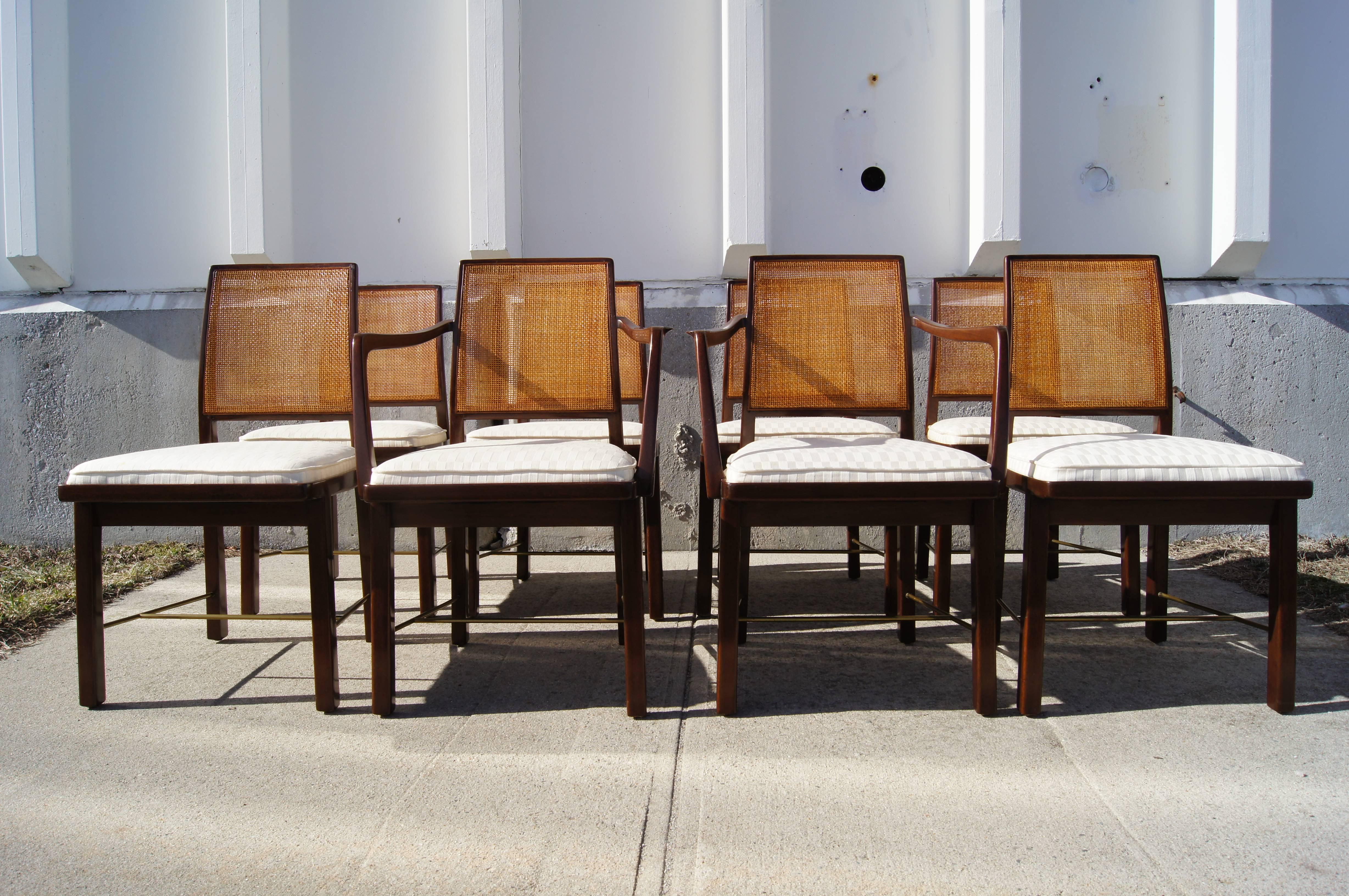 
Edward Wormley designed this set of dining chairs, six side and two armchairs (model numbers 5606 & 5607), for Dunbar's Janus line. The sculpted mahogany chairs feature square caned backs and brass H-stretchers.

The height of the arms on the