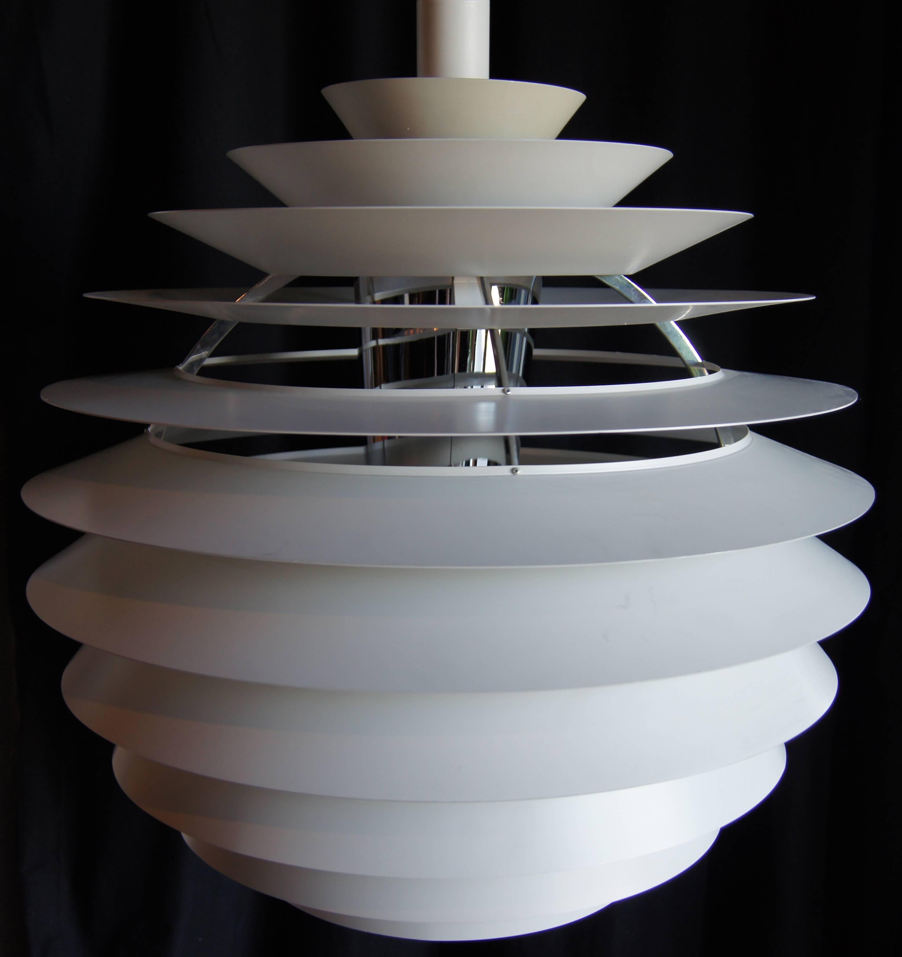 Poul Henningsen designed this pendant lamp for Louis Poulsen in 1957. The white lacquered metal tiers form an elongated globe that emits an even light.

Note that this fixture has a European socket; bulb and canopy not included.