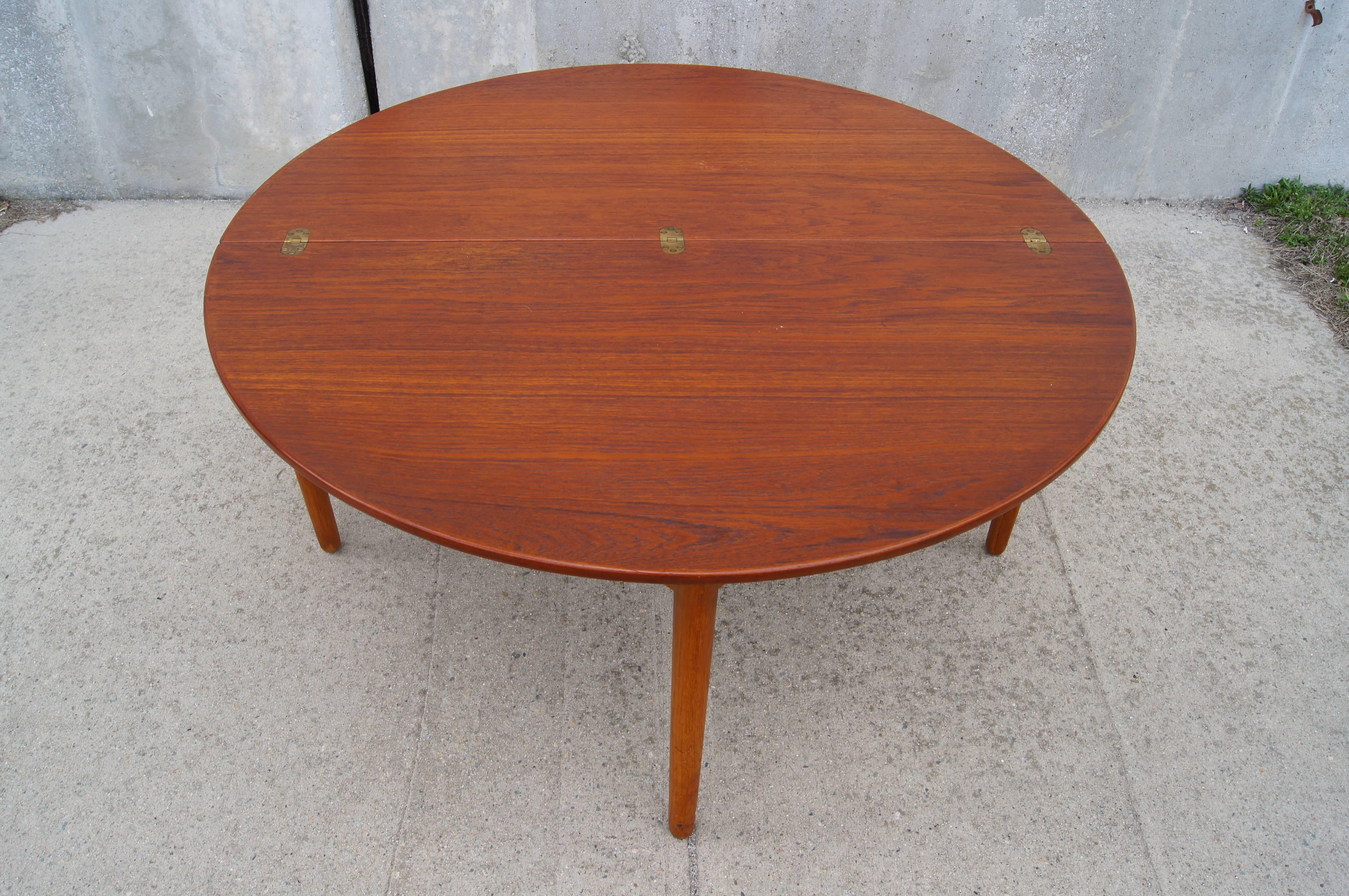 Paul Volther designed this round teak coffee table for the Danish company Frem Røjle in 1956. The hinged top folds over and a leg tucks away to create a demilune table perfect when a smaller footprint is desired.