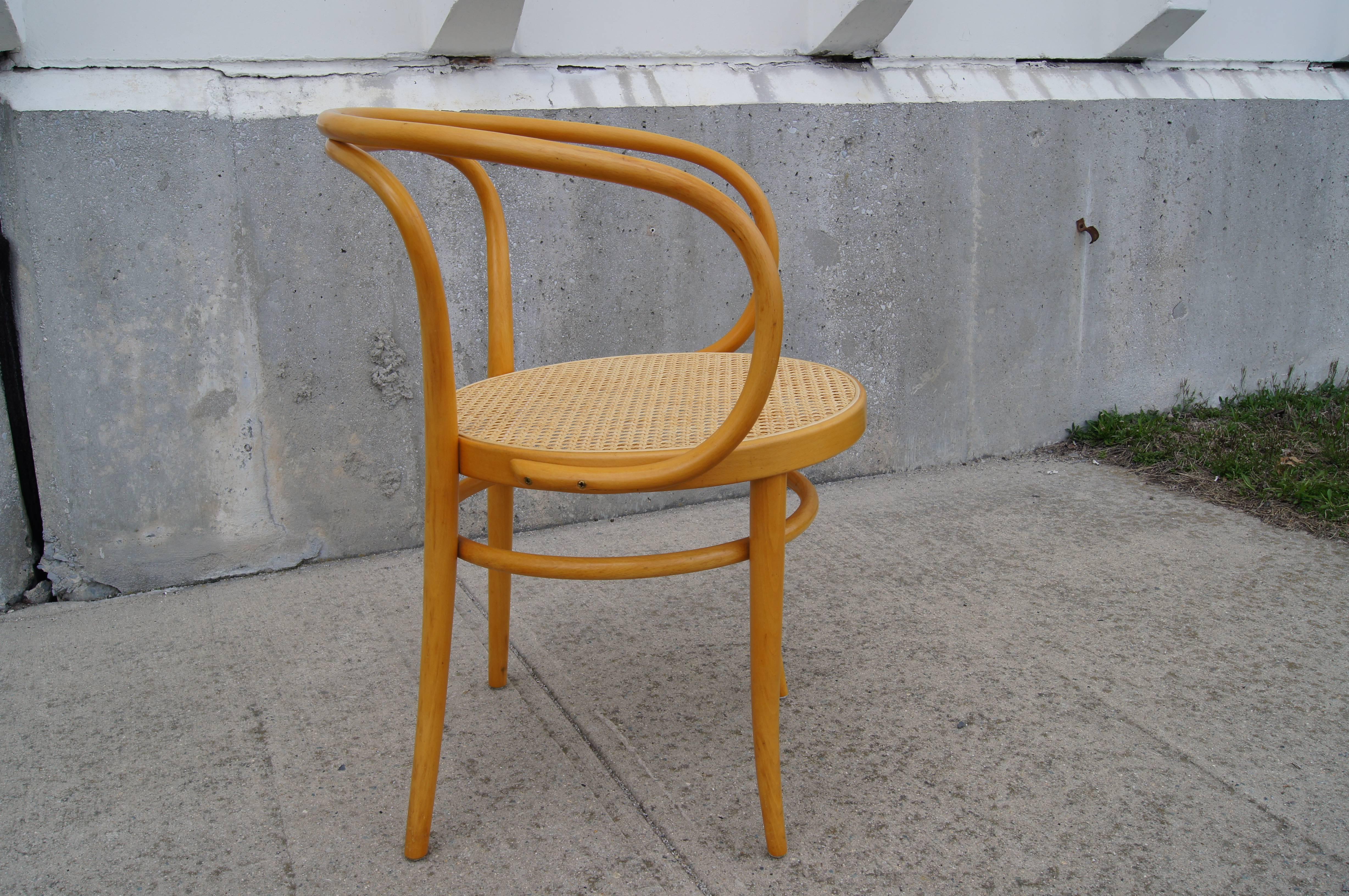 Lightweight and comfortable, this classic armchair from Thonet has a cane seat and a bentwood frame of solid beech, with both the armrest and the backrest and back legs moulded from a single piece. A favourite of architects, the 209 was famously