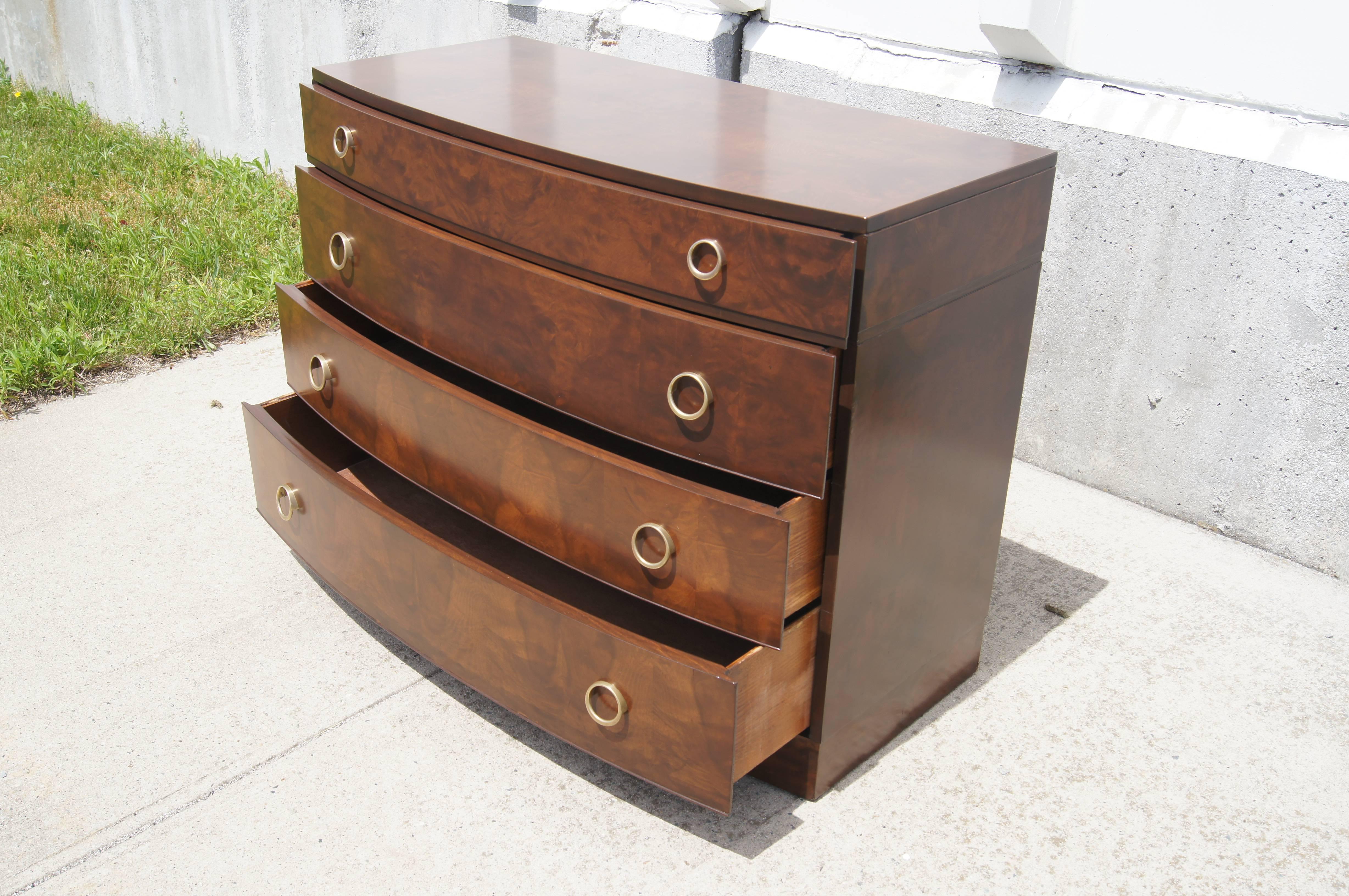 This bow-front dresser is a great example of American Art Deco furniture from the 1930s. Raised circular brass pulls complement the handsome myrtle burl.

