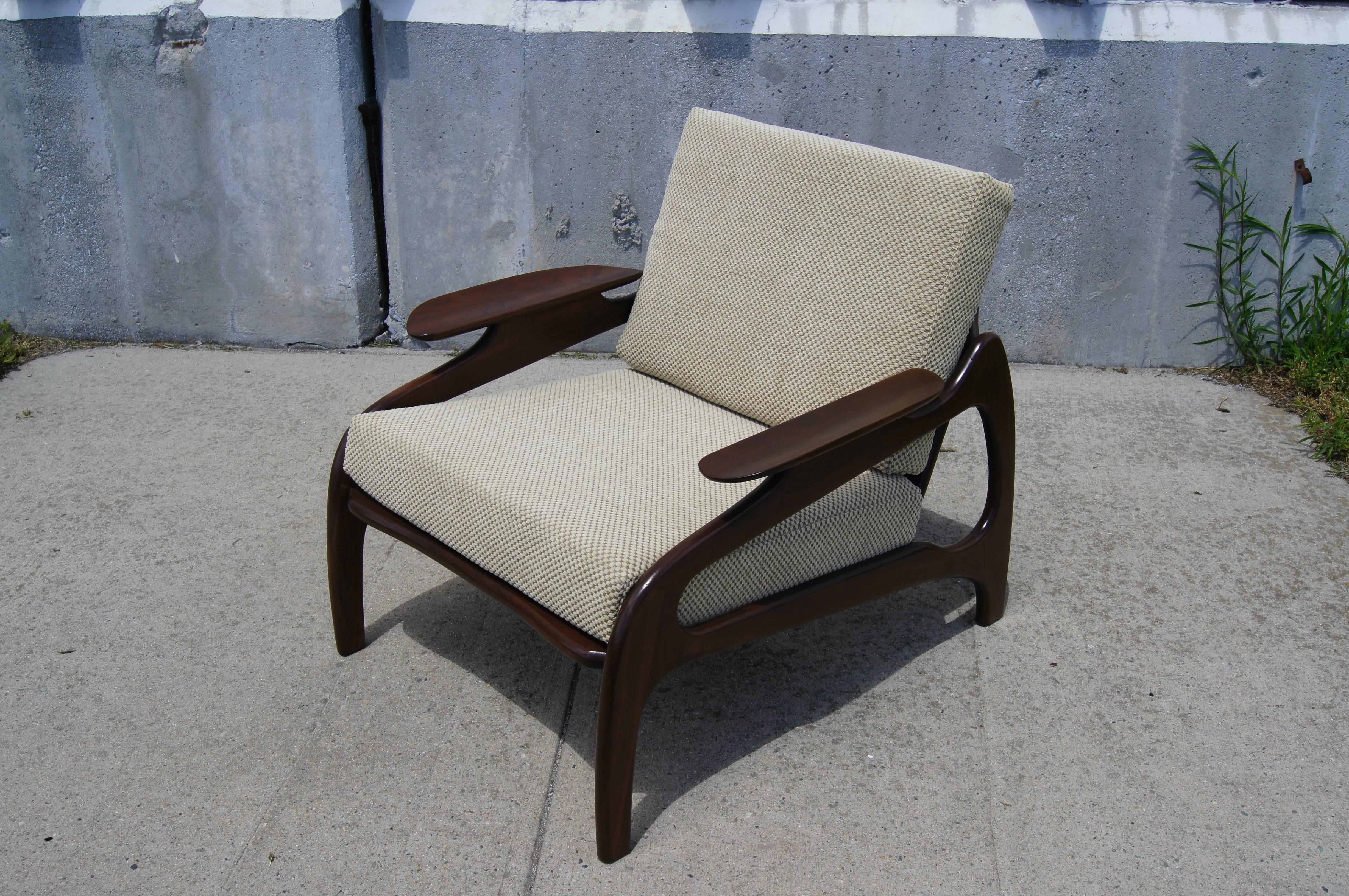 Designed by Adrian Pearsall and manufactured by his company Craft Associates, this cane-back lounge chair is as comfortable as it is stylish. The contoured legs and scooped armrests of the walnut frame create a wonderful low-slung organic form.