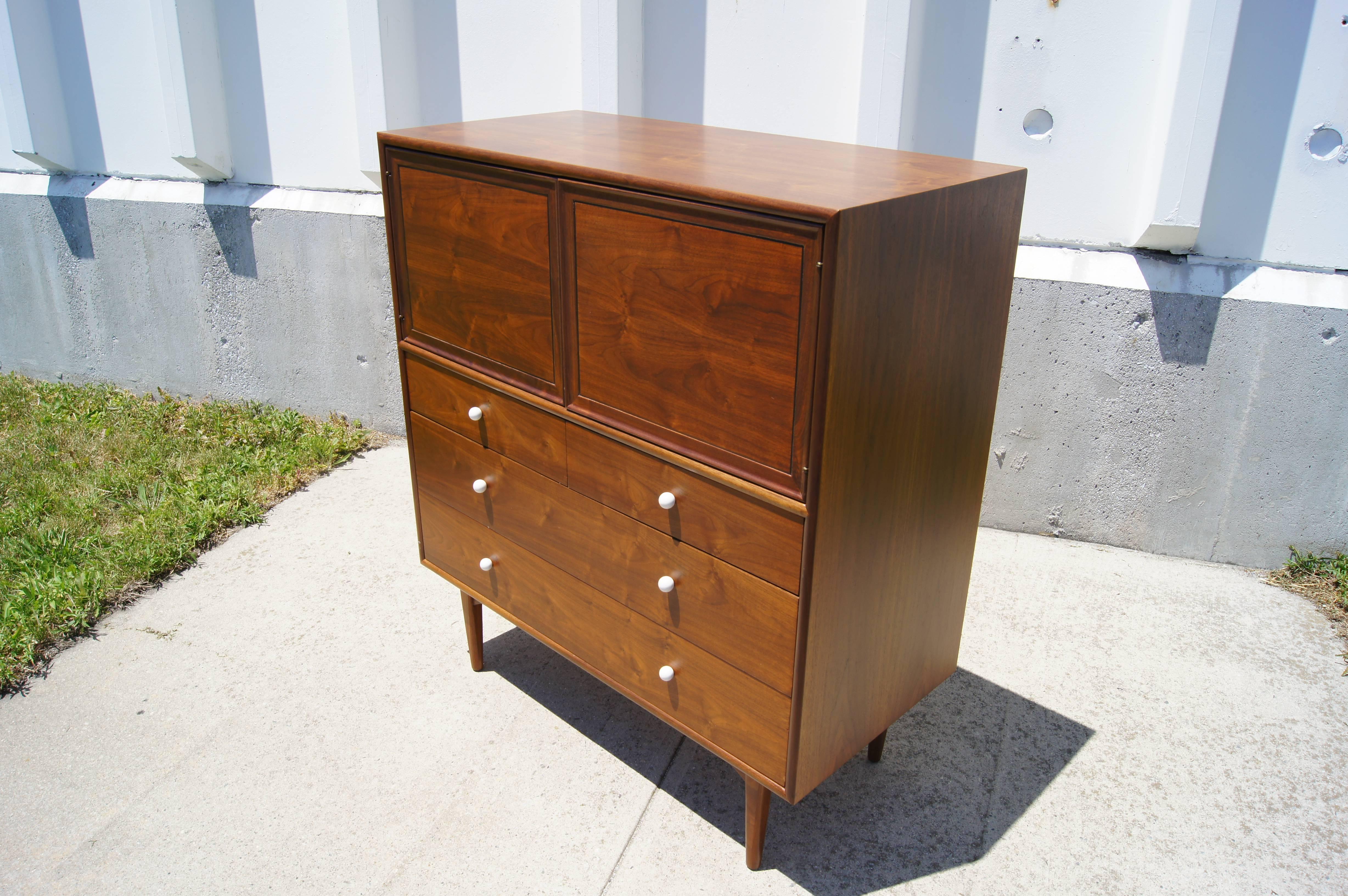 Kipp Stewart and Stewart MacDougall designed this gentlemen's dresser as part of Drexel's popular Declaration collection. Their signature white porcelain pulls highlight the beauty of the oiled walnut.

Three drawers sit atop tapered legs of solid
