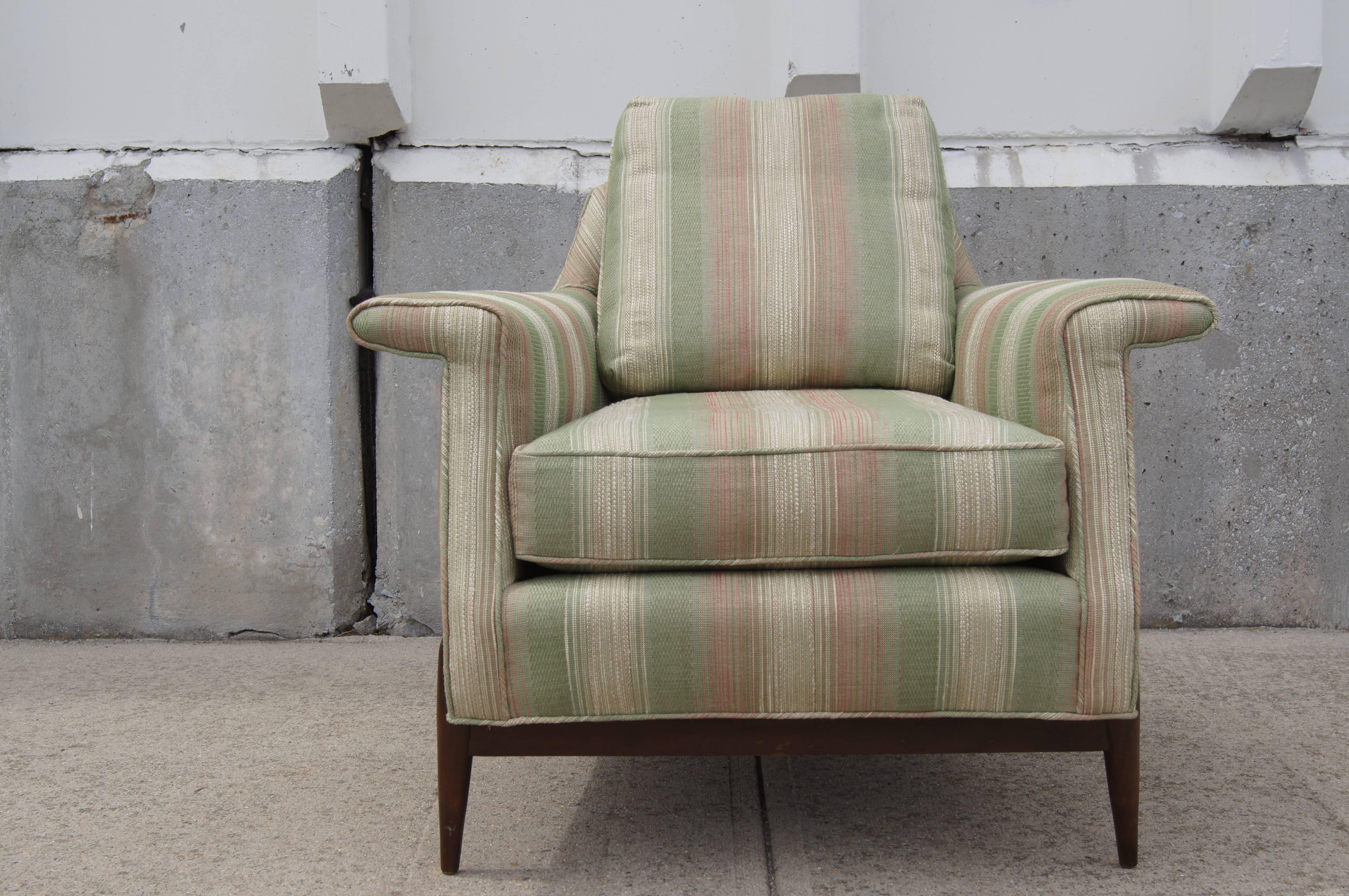 With its wide winglike ams, tapered back and rounded walnut legs emerging from the upholstered body, this mid-century lounge chair has plenty of charm. 

 