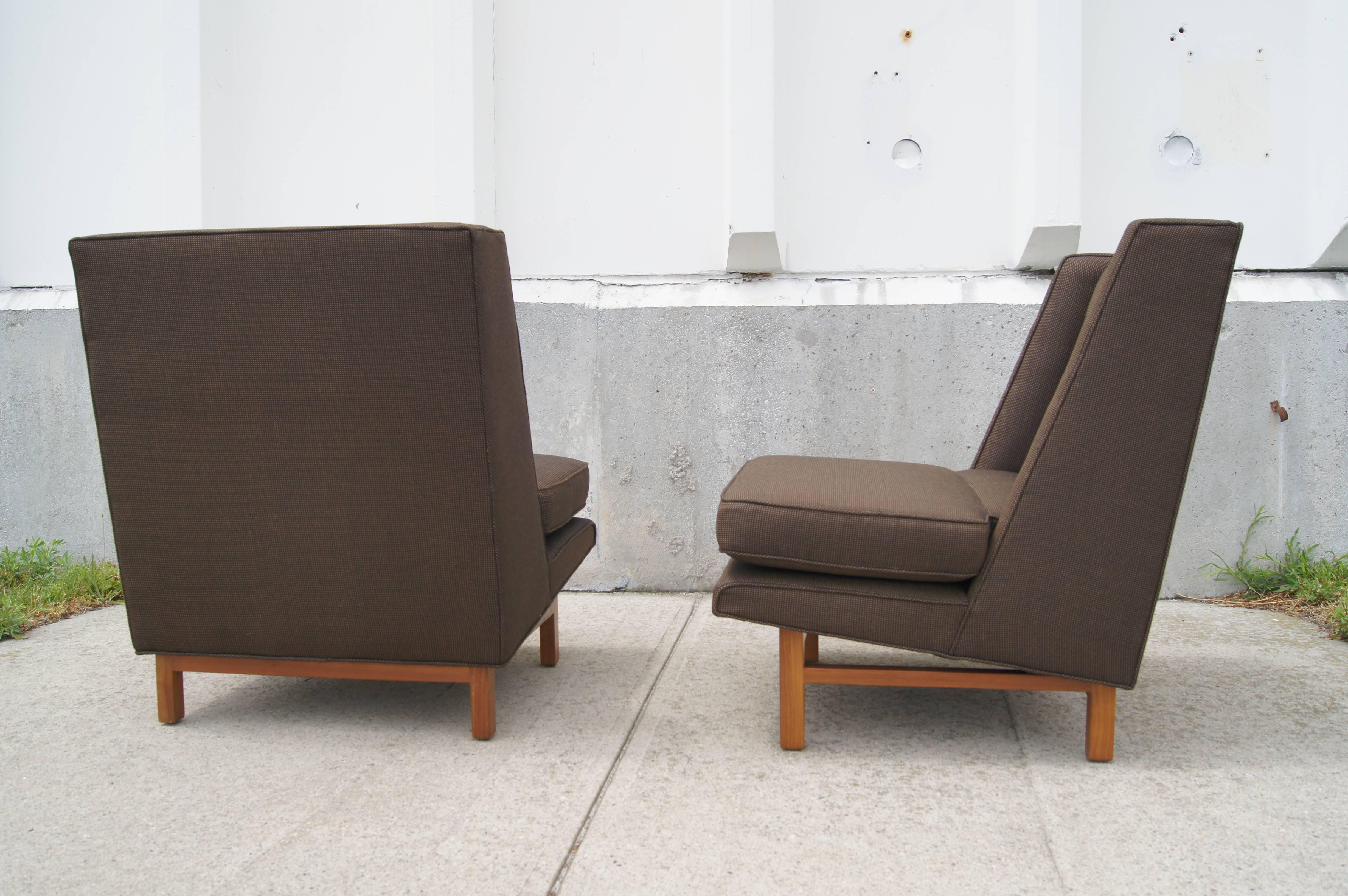 Edward Wormley designed these clean-lined wing chairs, model # 5938, for Dunbar's New Career Collection. A sloping back rises from low, wide seats that angle up from the mahogany base.  

These rare chairs have been newly reupholstered in Knoll's