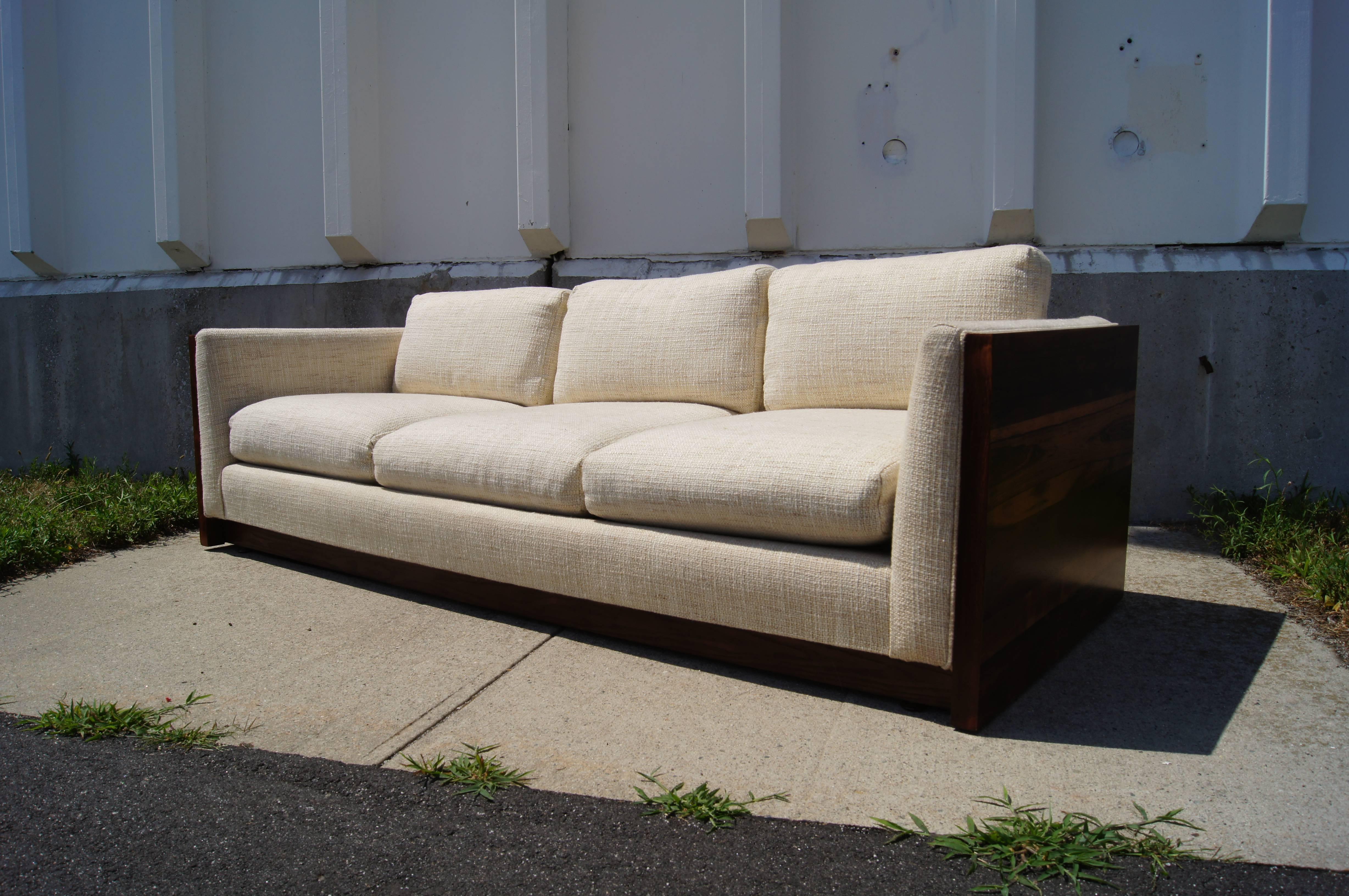 Milo Baughman created this 1960s case sofa for Forecast Furniture. Two gorgeous panels of Brazilian rosewood frame the upholstered seat and give the piece the clean lines typical of the designer's work.