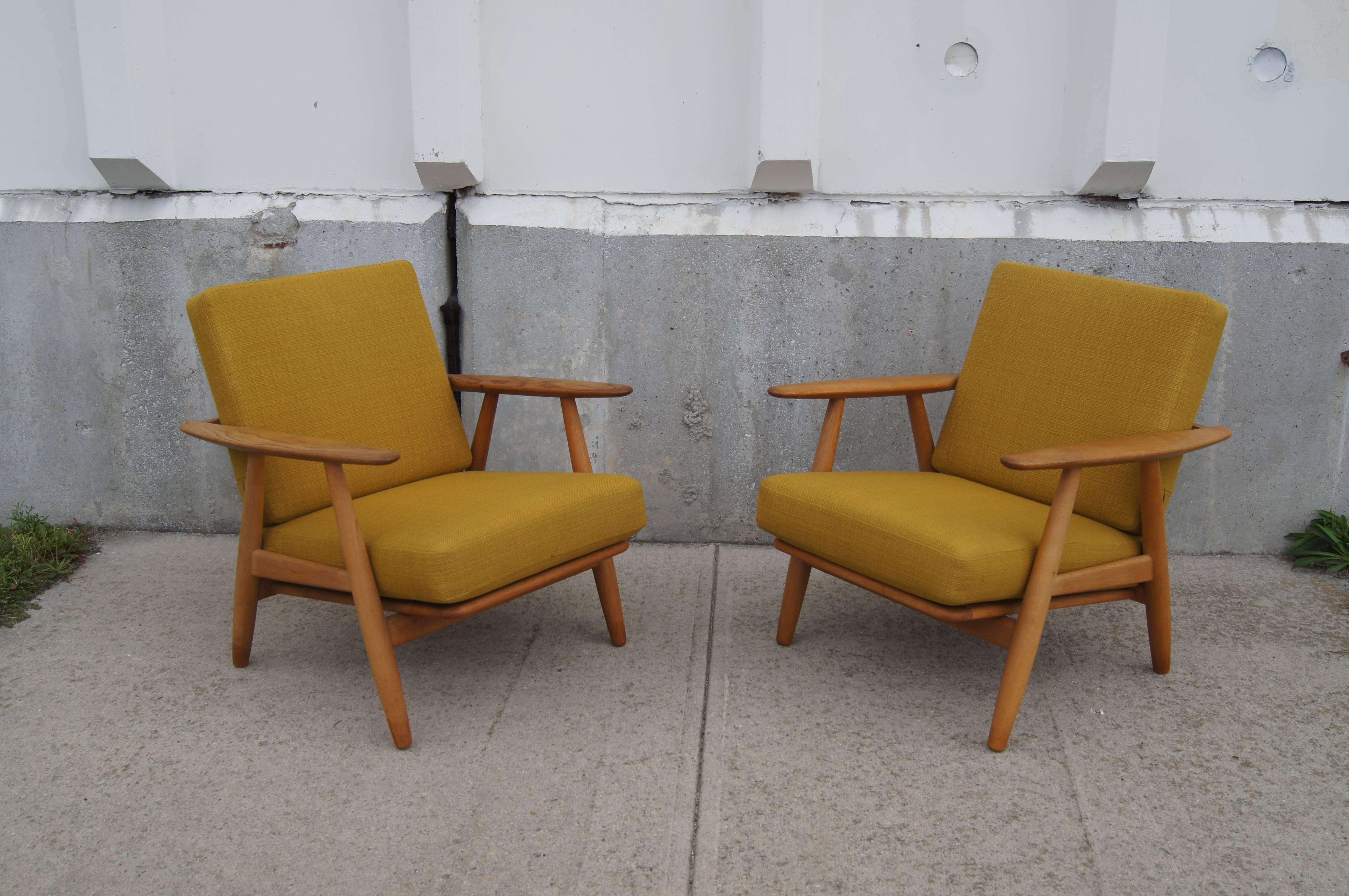 Hans Wegner designed the GE240 in 1955 for GETAMA. The gently curved lines of the armrests inspired the name Cigar chair. These comfortable armchairs have a lovely oak frames and their original sprung cushions in a yellow-green textile.