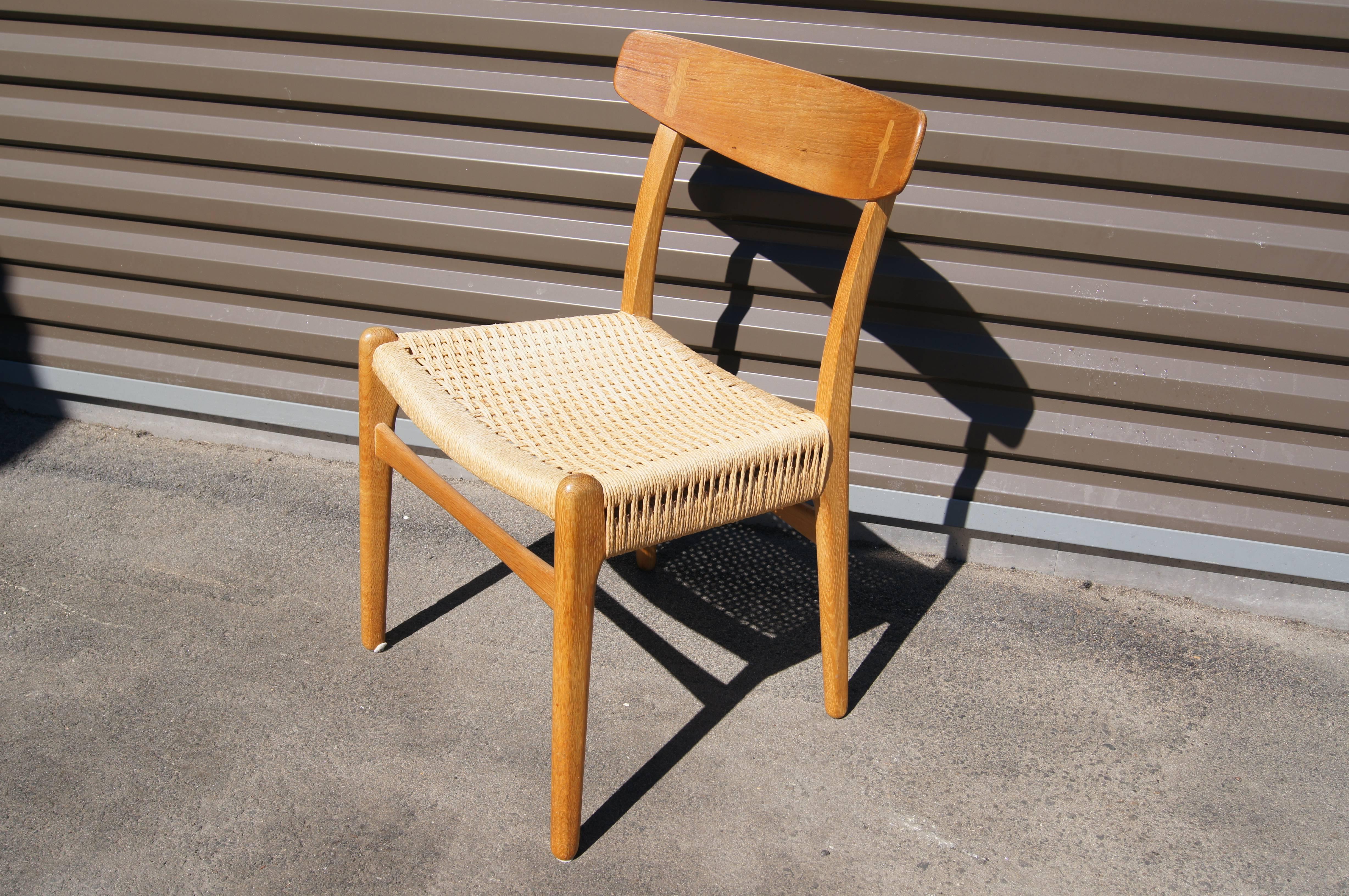 One of Hans Wegner's early designs for Carl Hansen & Søn, these comfortable but refined dining chairs feature solid oak frames with contrasting curved teak backrests with exposed joints. The seats are the original handwoven papercord.