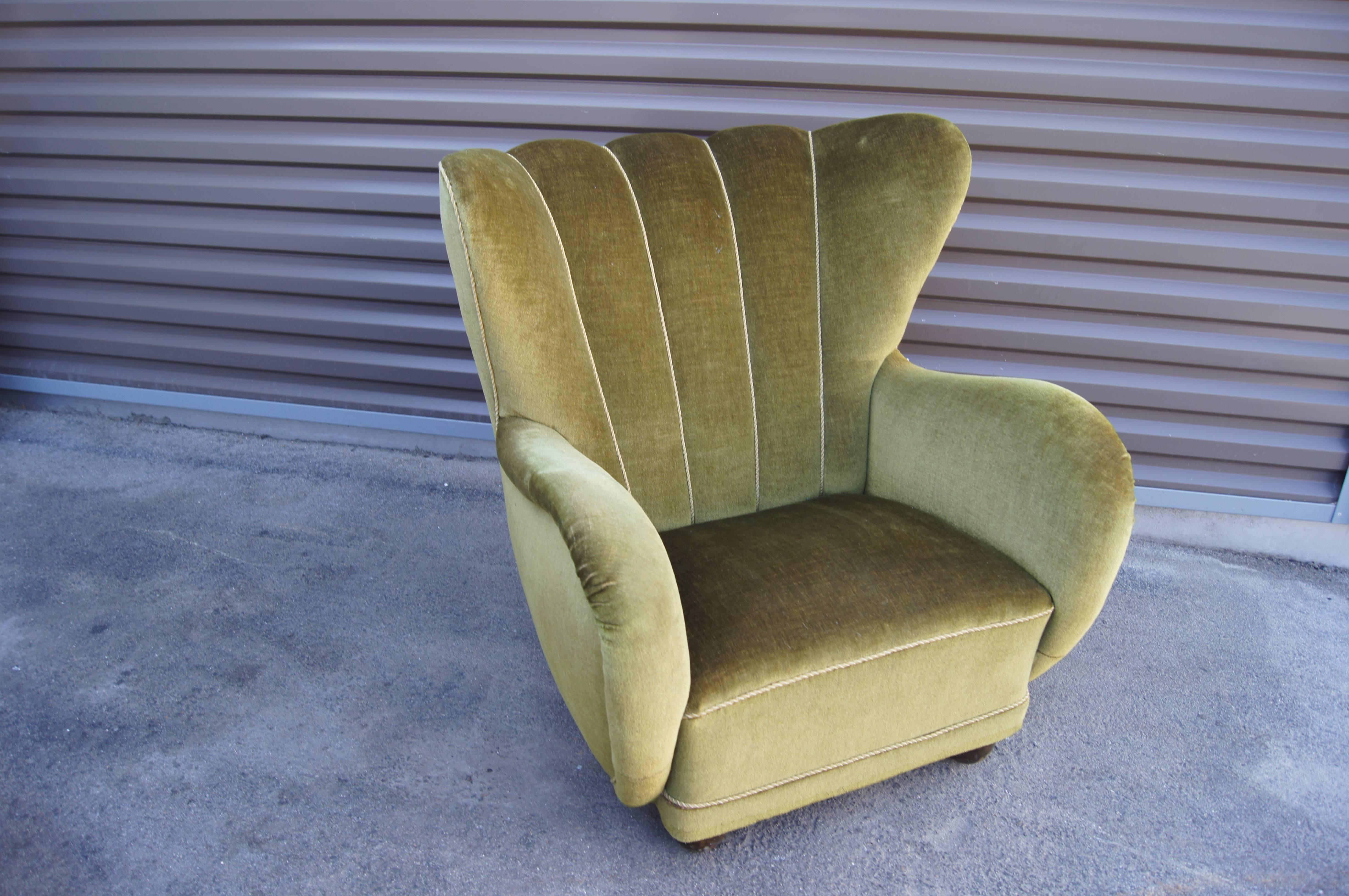 The exuberant curves of this Danish Art Deco club chair immediately catch the eye. Set on block feet typical of the period and with a deeply channeled back, it is beautifully upholstered in a lustrous moss green mohair.